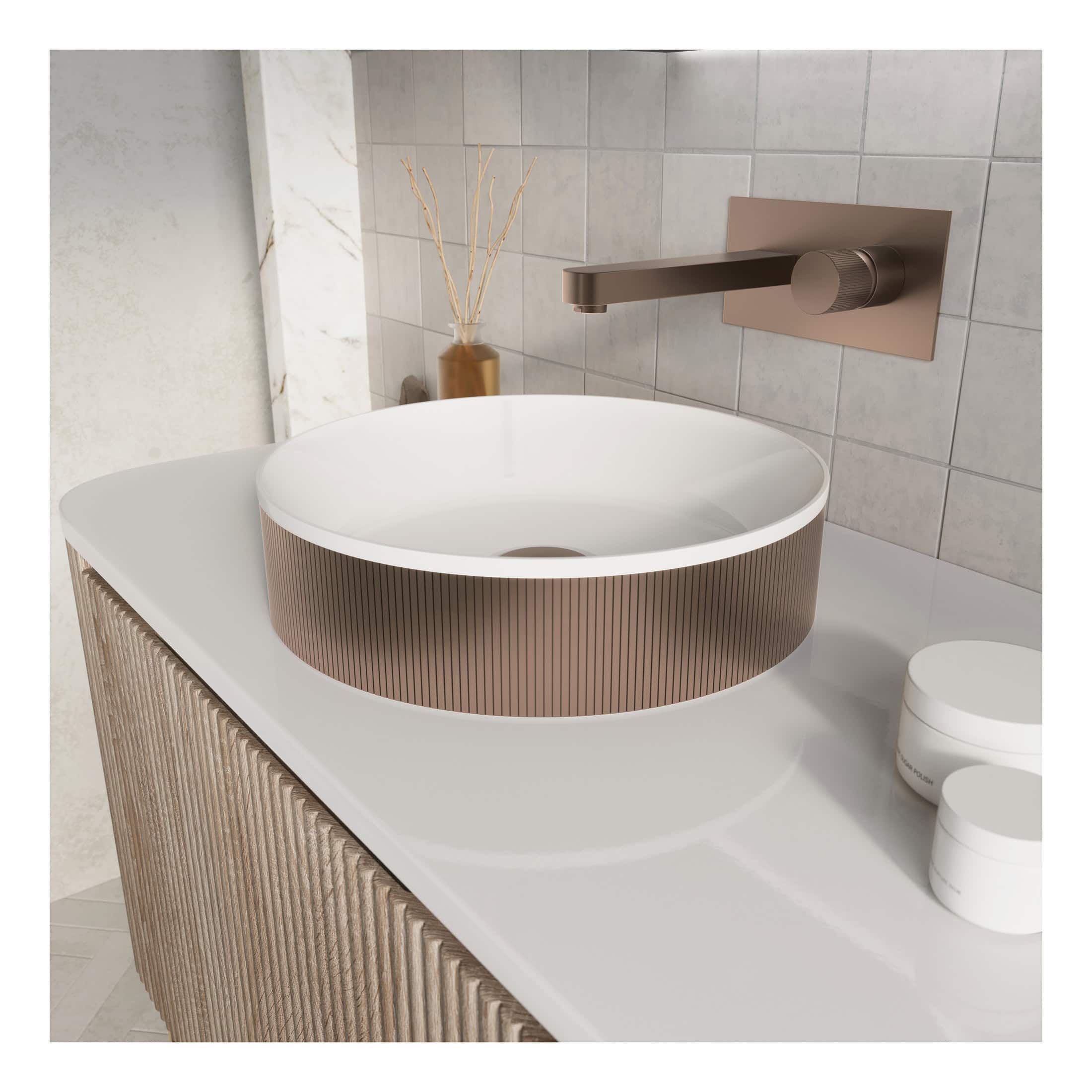 Sleek modern bathroom sink with a round vessel basin and copper-toned textured exterior, mounted on a white countertop with a matte bronze wall-mounted faucet, complemented by minimalist decor.