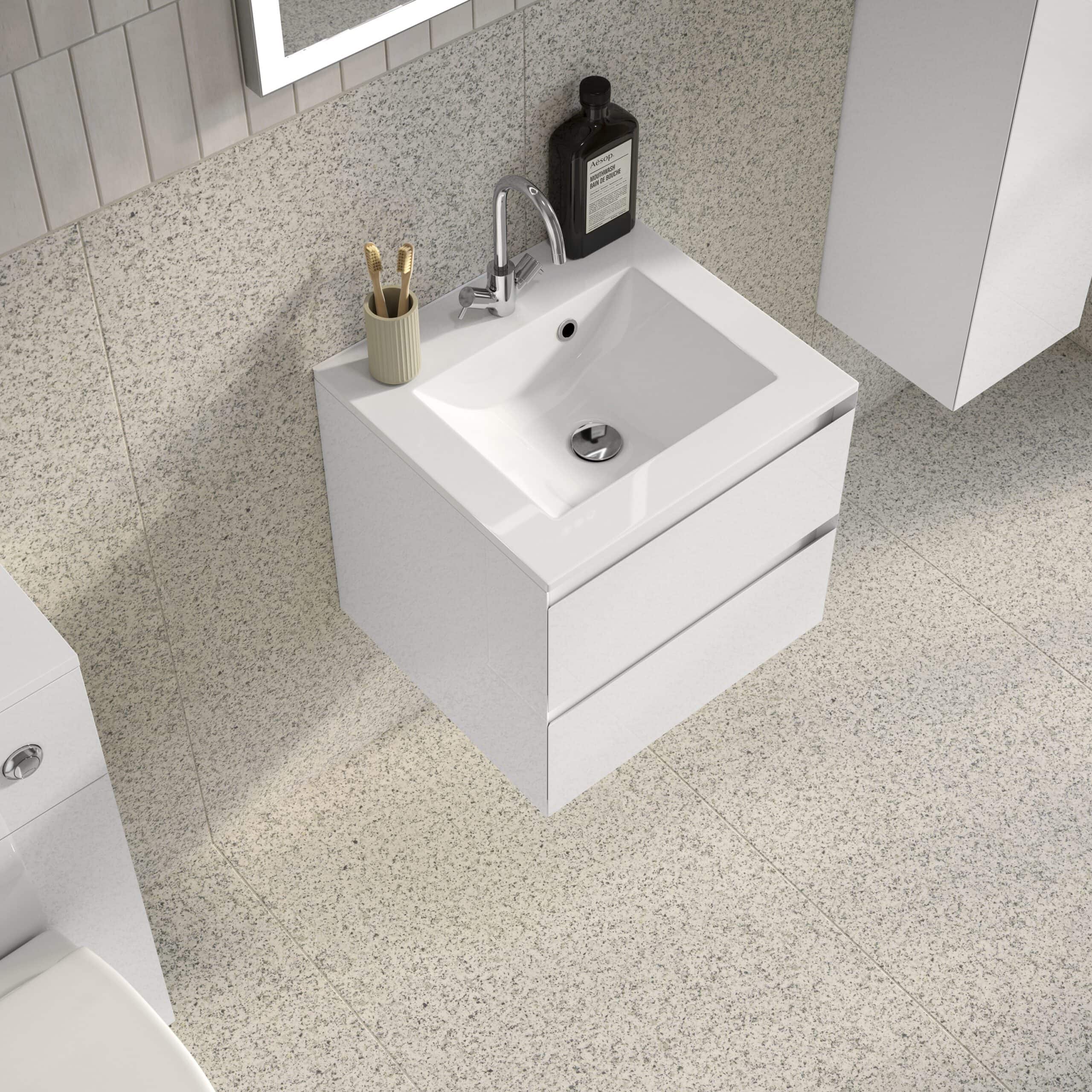 Contemporary white bathroom vanity with integrated sink, minimalist storage drawers, and modern chrome tap, set against textured beige wall and flooring for a sleek, functional bathroom design.