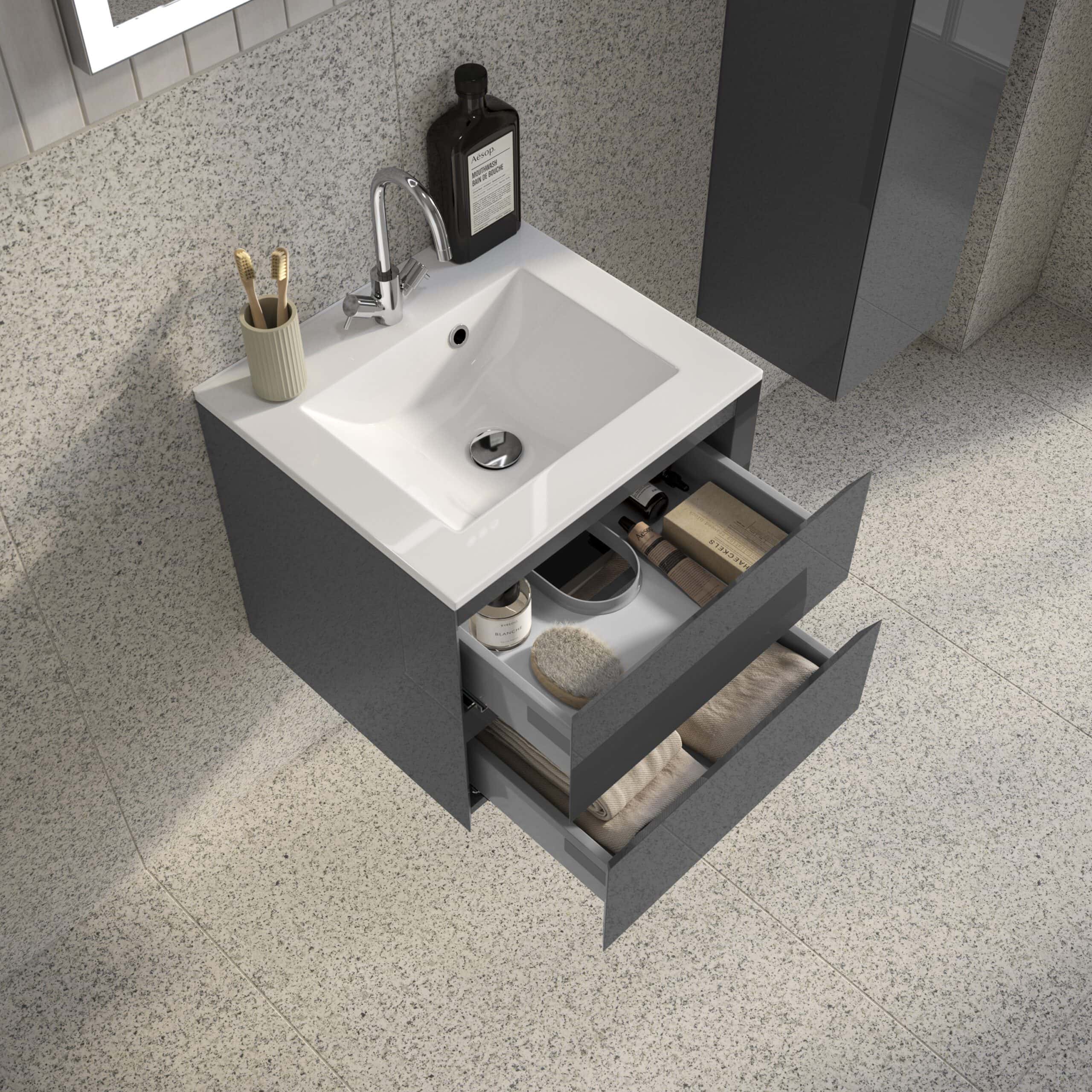 Sleek modern grey bathroom vanity with open drawers filled with towels, toiletries, and bathroom accessories, set against a speckled wall and flooring, showcasing contemporary bathroom furniture.