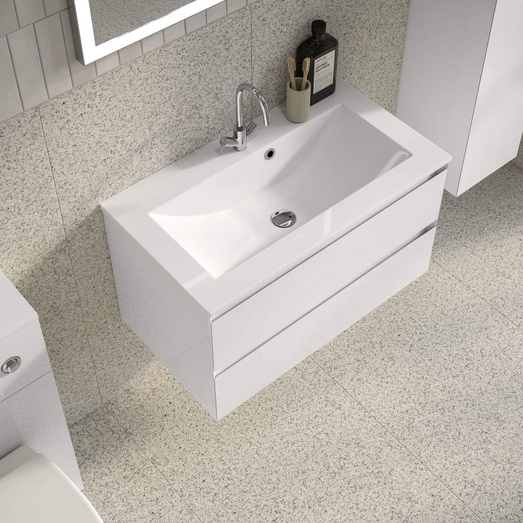Sleek white bathroom vanity with integrated sink and modern chrome tap, complemented by minimalist accessories on a neutral textured wall for a contemporary bathroom look.