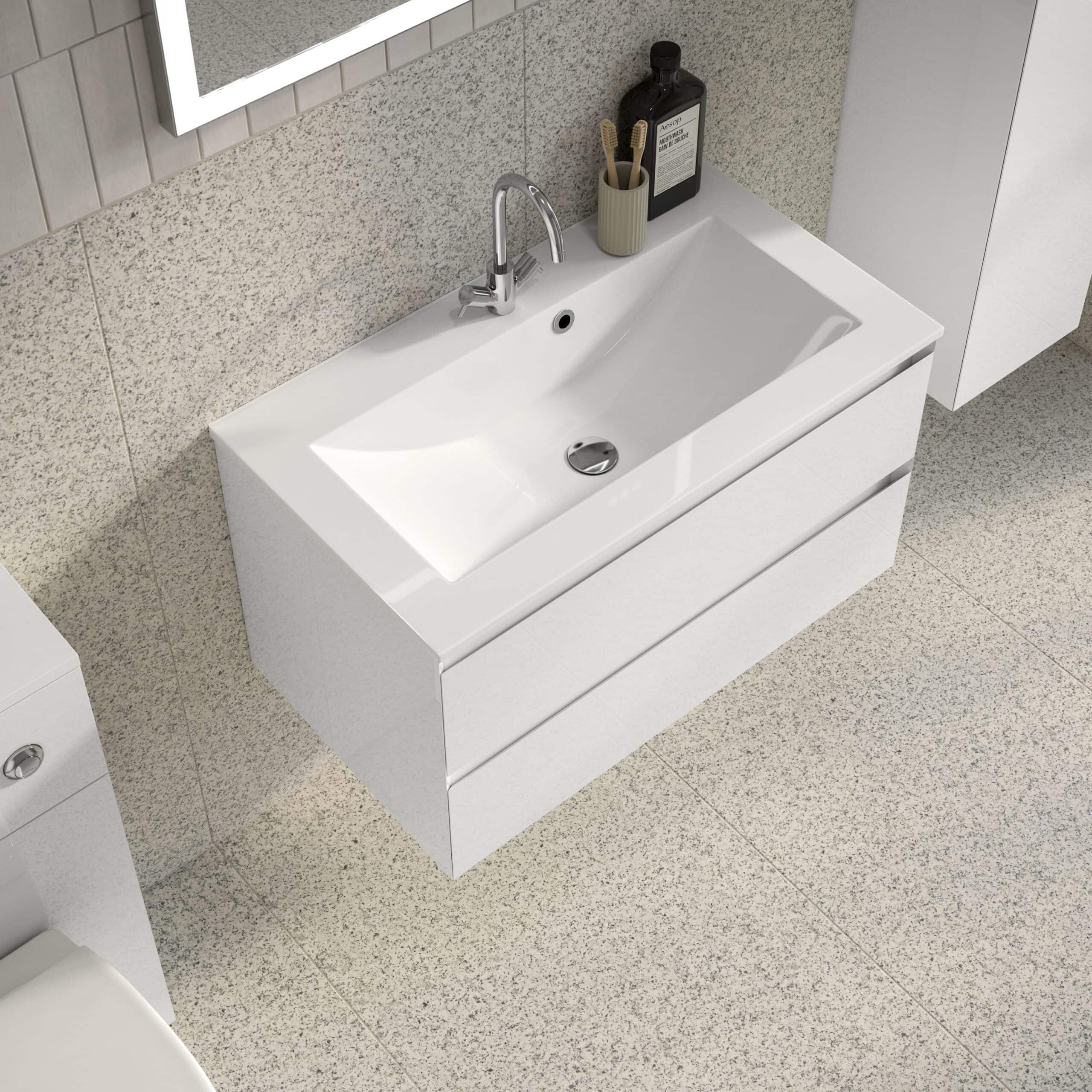 Sleek white bathroom vanity with integrated sink and modern chrome tap, complemented by minimalist accessories on a neutral textured wall for a contemporary bathroom look.