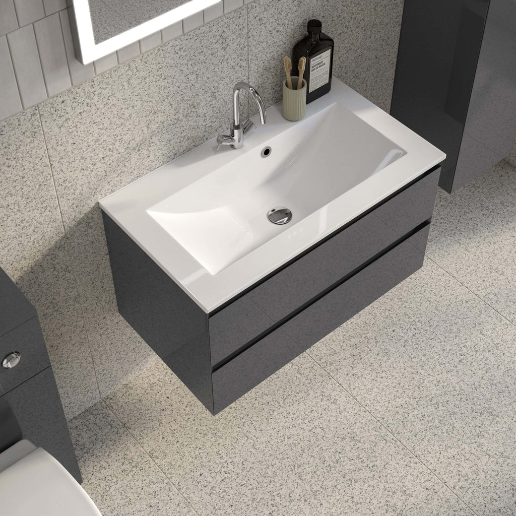 Modern bathroom sink with black vanity unit and chrome tap, accompanied by bathroom essentials like hand wash and toothbrush holder, in a sleek and contemporary bathroom design.