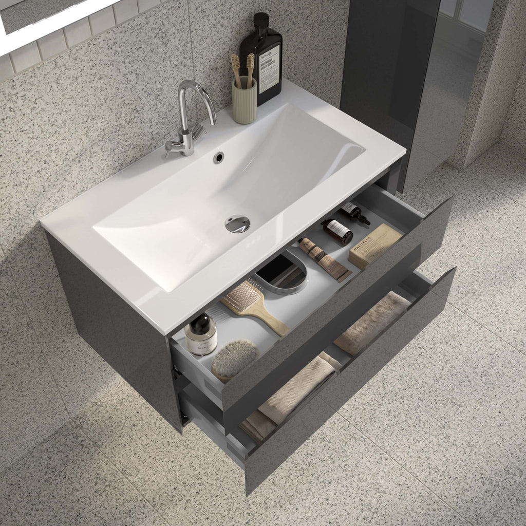 Sleek modern bathroom vanity with open drawer storage, white ceramic sink, chrome tap, and organised bathroom essentials on beige speckled flooring and granite wall backdrop.
