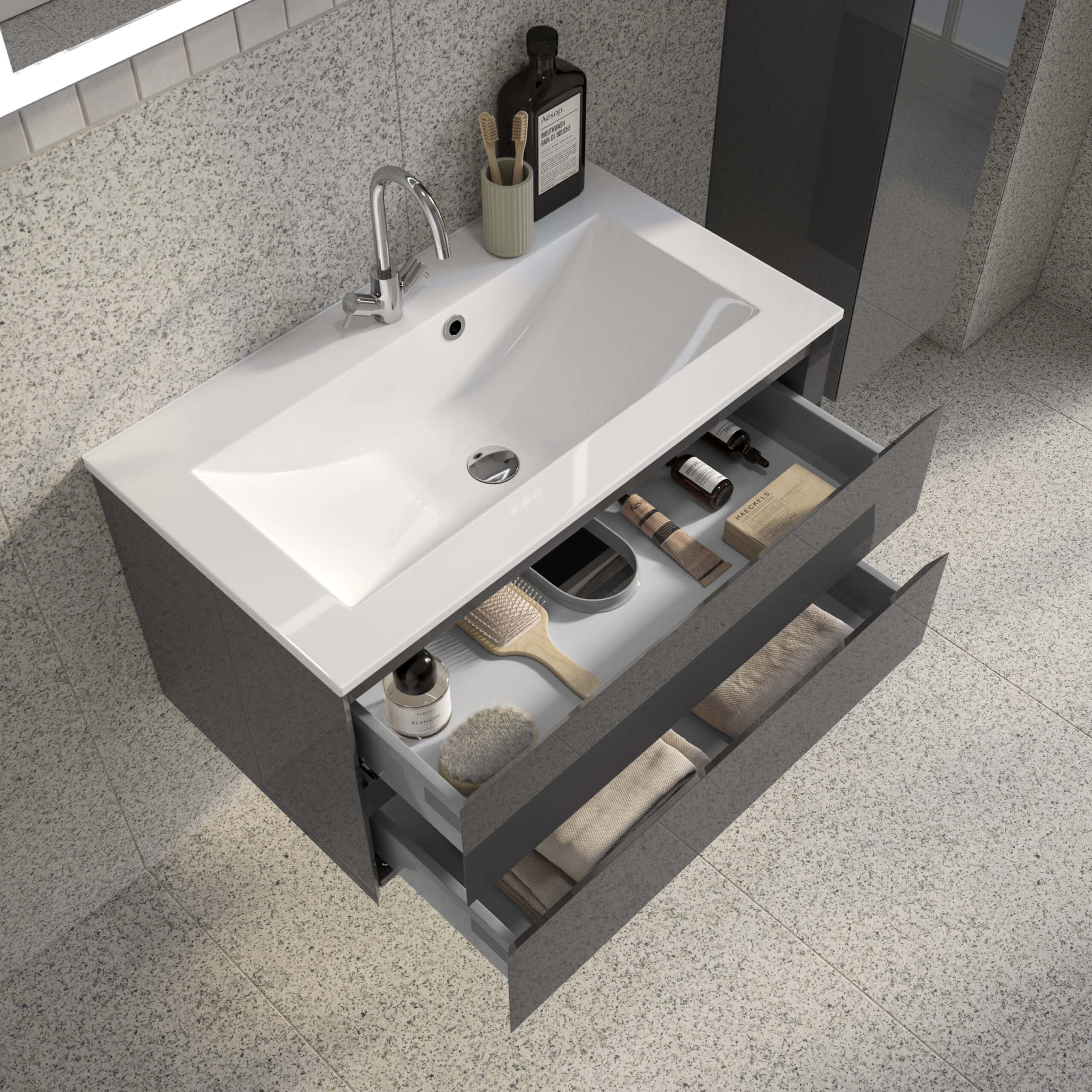 Sleek modern bathroom vanity with open drawer storage, white ceramic sink, chrome tap, and organised bathroom essentials on beige speckled flooring and granite wall backdrop.