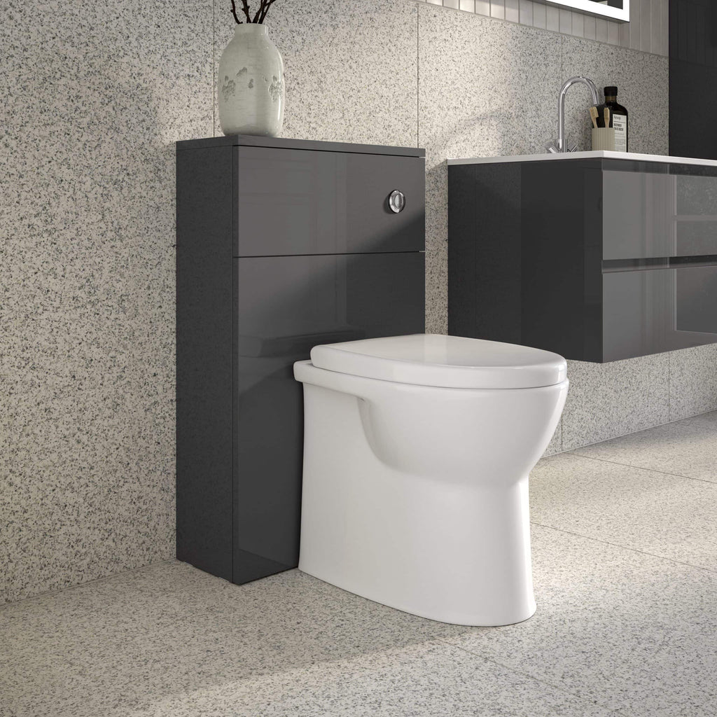 Sleek modern bathroom featuring a white toilet against a textured wall, with a dark grey storage unit and a matching vanity with a sink, embodying contemporary bathroom design.