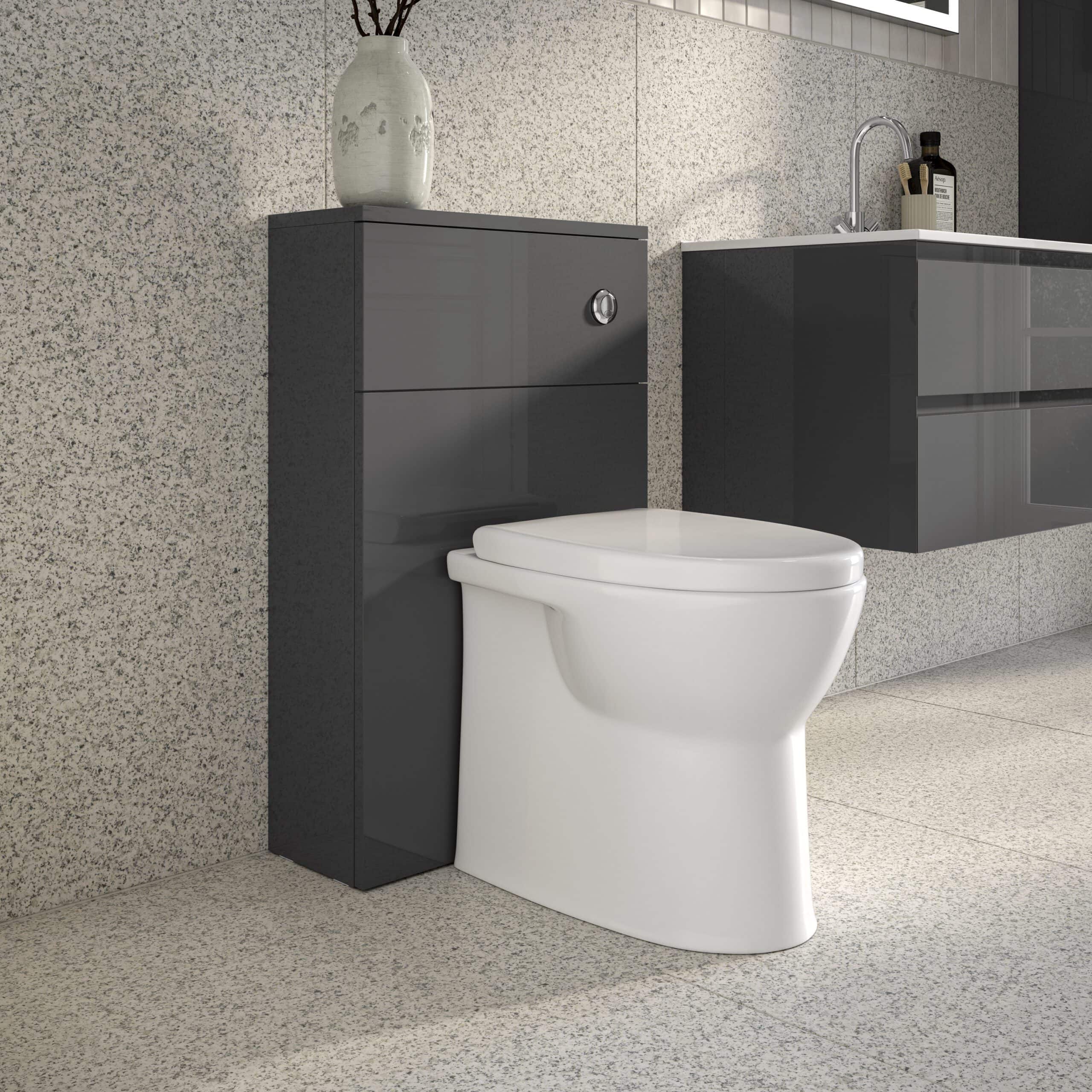 Sleek modern bathroom featuring a white toilet against a textured wall, with a dark grey storage unit and a matching vanity with a sink, embodying contemporary bathroom design.