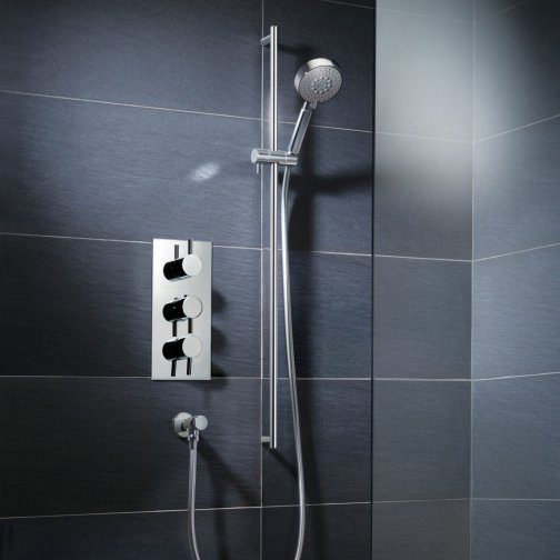 Shower panel with adjustable controls and hand-held showerhead in modern bathroom.