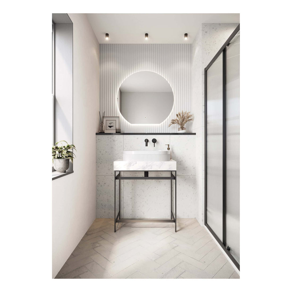 Minimalist modern bathroom with round backlit mirror, white terrazzo vanity, black fixtures, and sleek black-framed glass shower enclosure, perfect for contemporary bathroom design.