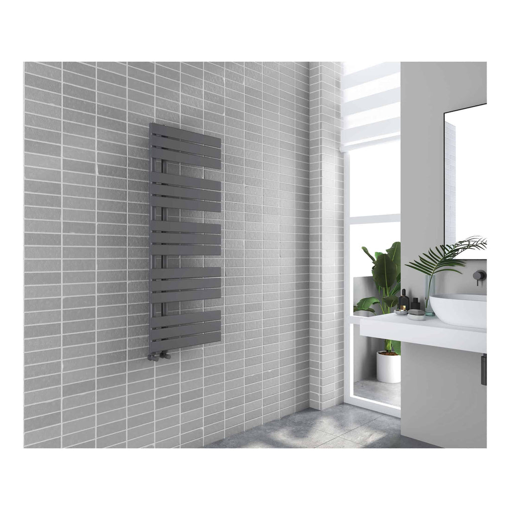 Vertical black radiator in modern grey tiled bathroom with white sink and potted plant, stylish bathroom heating solution, contemporary design, bathroom decor, Bubly Bathrooms UK.