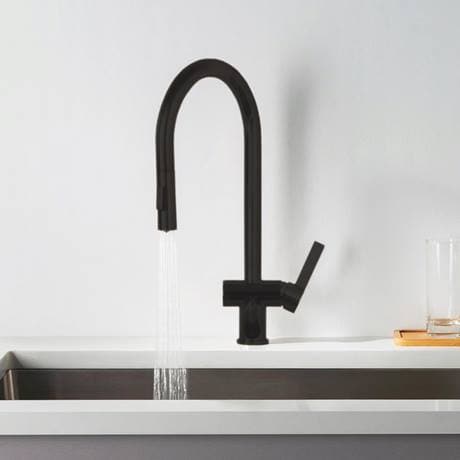 Sleek black kitchen tap with waterfall design installed over a white sink in a modern bathroom setting.