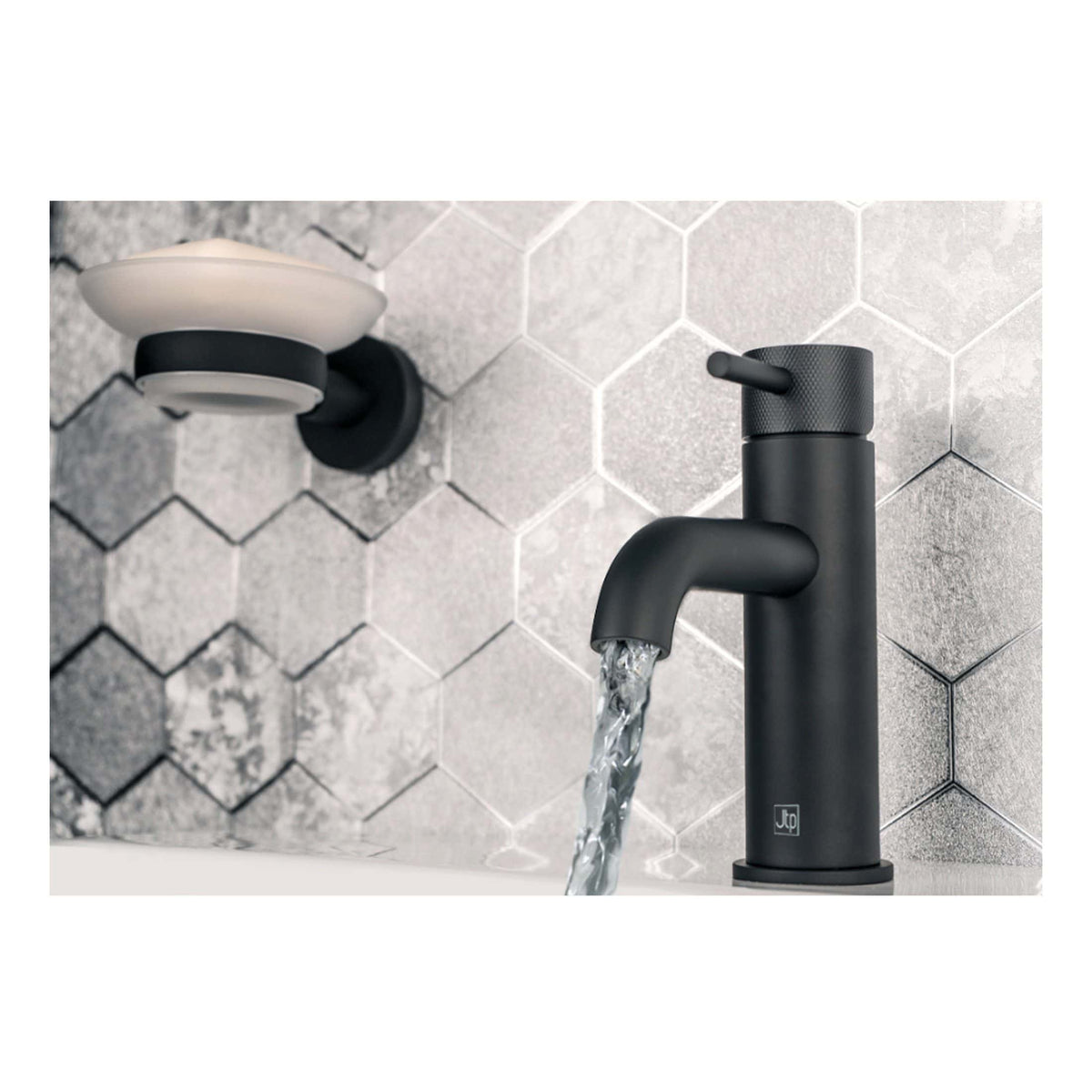 Sleek matte black bathroom tap with water flowing, modern bathroom sink fixture, against a textured grey tile wall, showcasing contemporary bathroom design and premium fixtures.