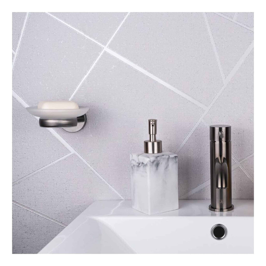 Sleek modern bathroom sink with chrome faucet, marble soap dispenser, and wall-mounted soap dish against textured grey tile wall. Perfect for stylish bathroom renovations.
