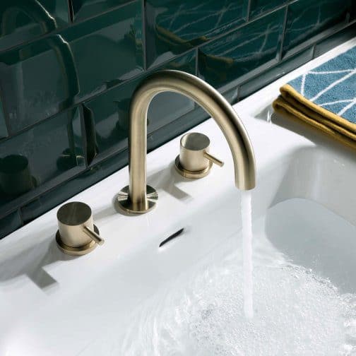 Sleek modern bathroom sink tap with running water, chrome finish, and green tiled wall background, ideal for contemporary bathroom design.