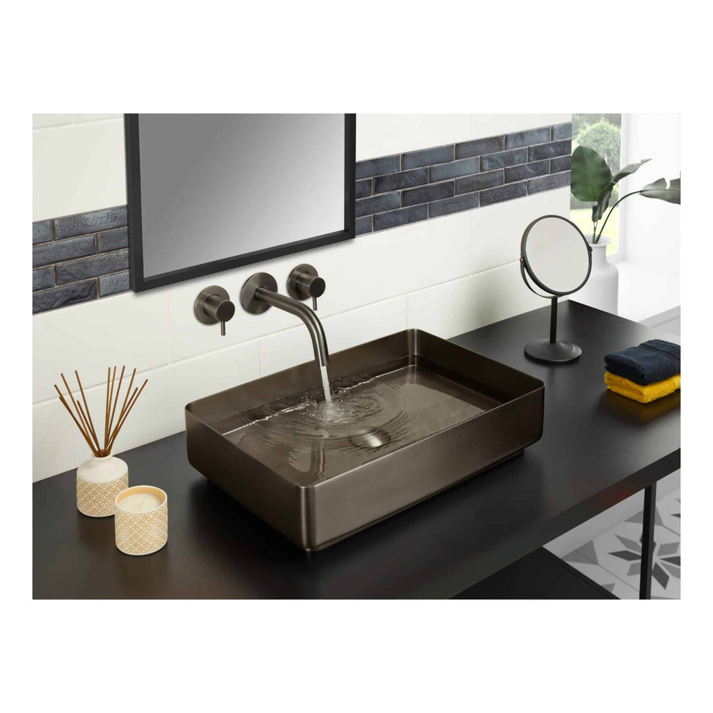 Sleek modern bathroom sink with matte black finish, wall-mounted faucet, and decorative accessories on a black countertop in contemporary bathroom decor.