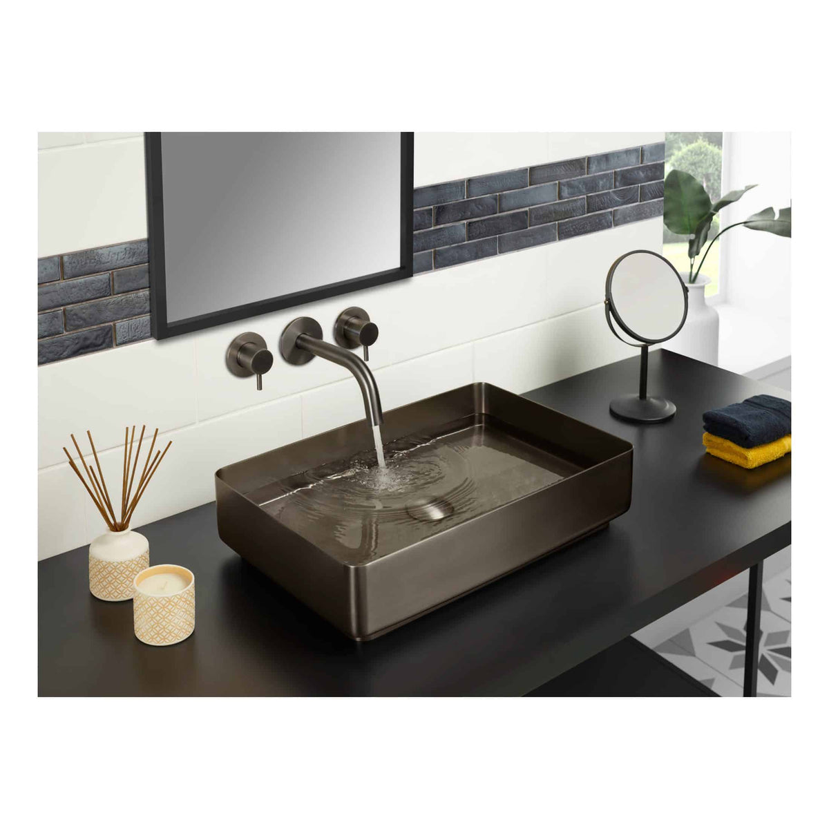 Sleek modern bathroom sink with matte black finish, wall-mounted faucet, and decorative accessories on a black countertop in contemporary bathroom decor.