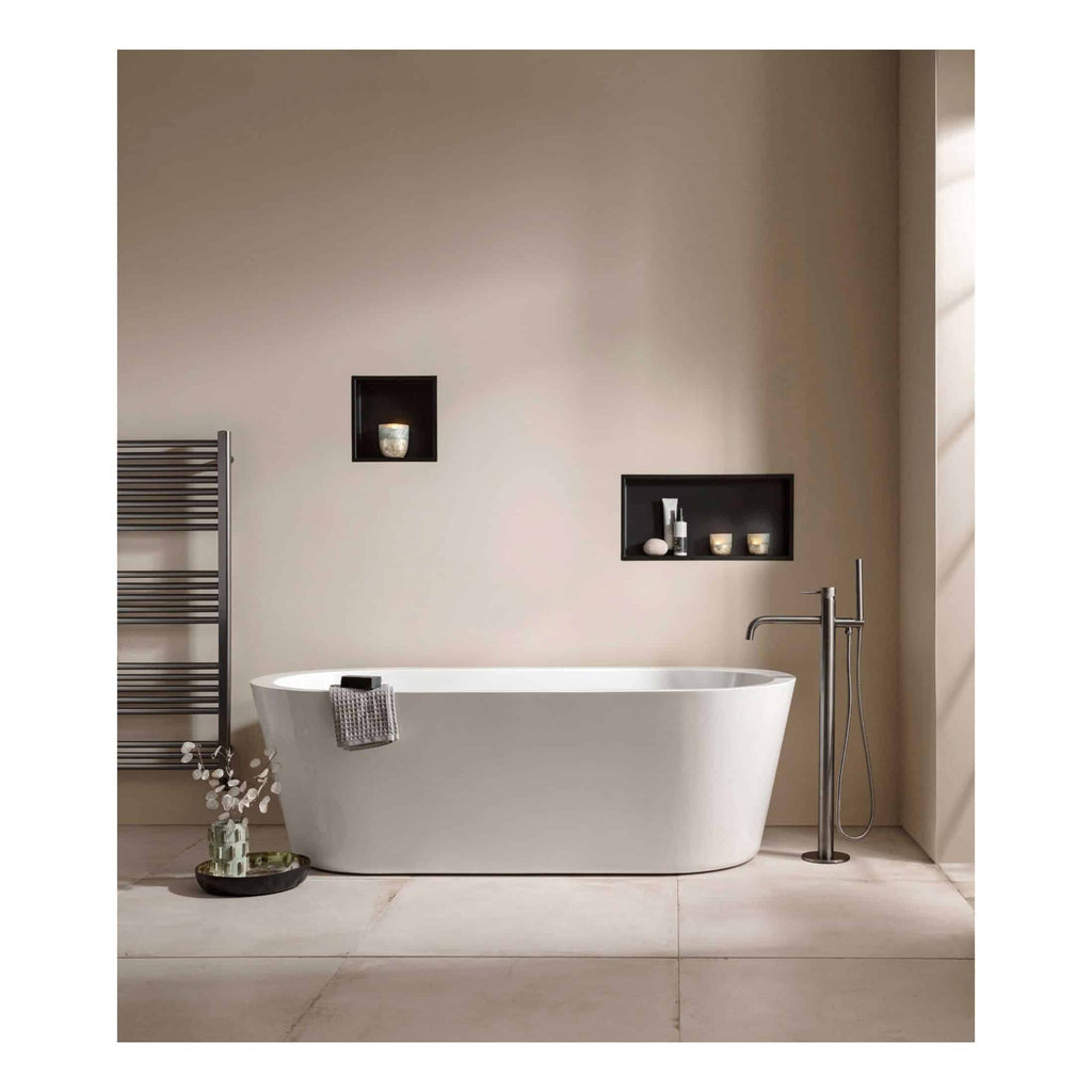 Sleek modern freestanding bathtub in a contemporary bathroom with minimalist decor and built-in wall niches for bath essentials, created by Bubly Bathrooms.