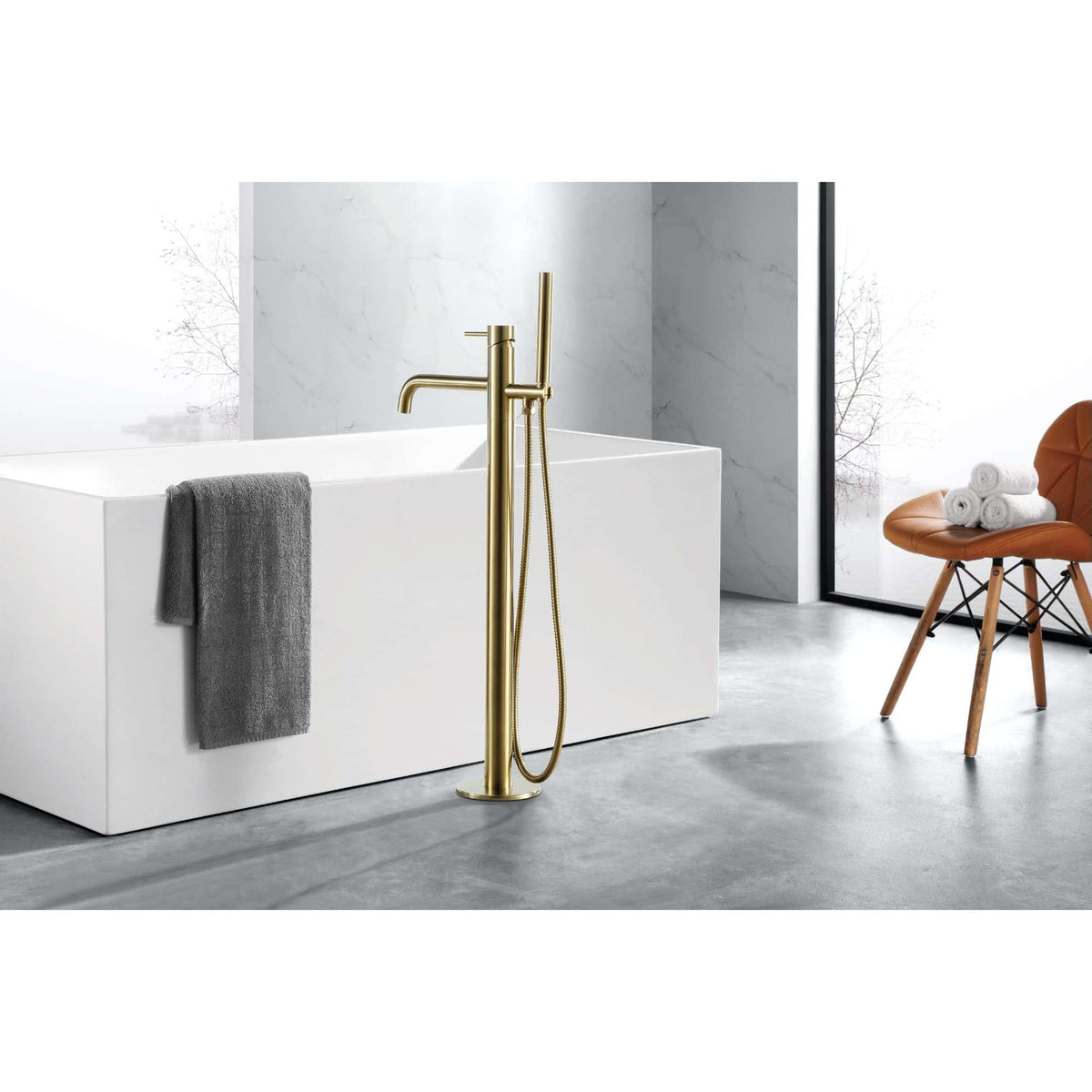Sleek modern freestanding bathtub with a minimalist design, complemented by a luxurious gold floor-mounted bath filler and handheld shower set in a contemporary bathroom setting.