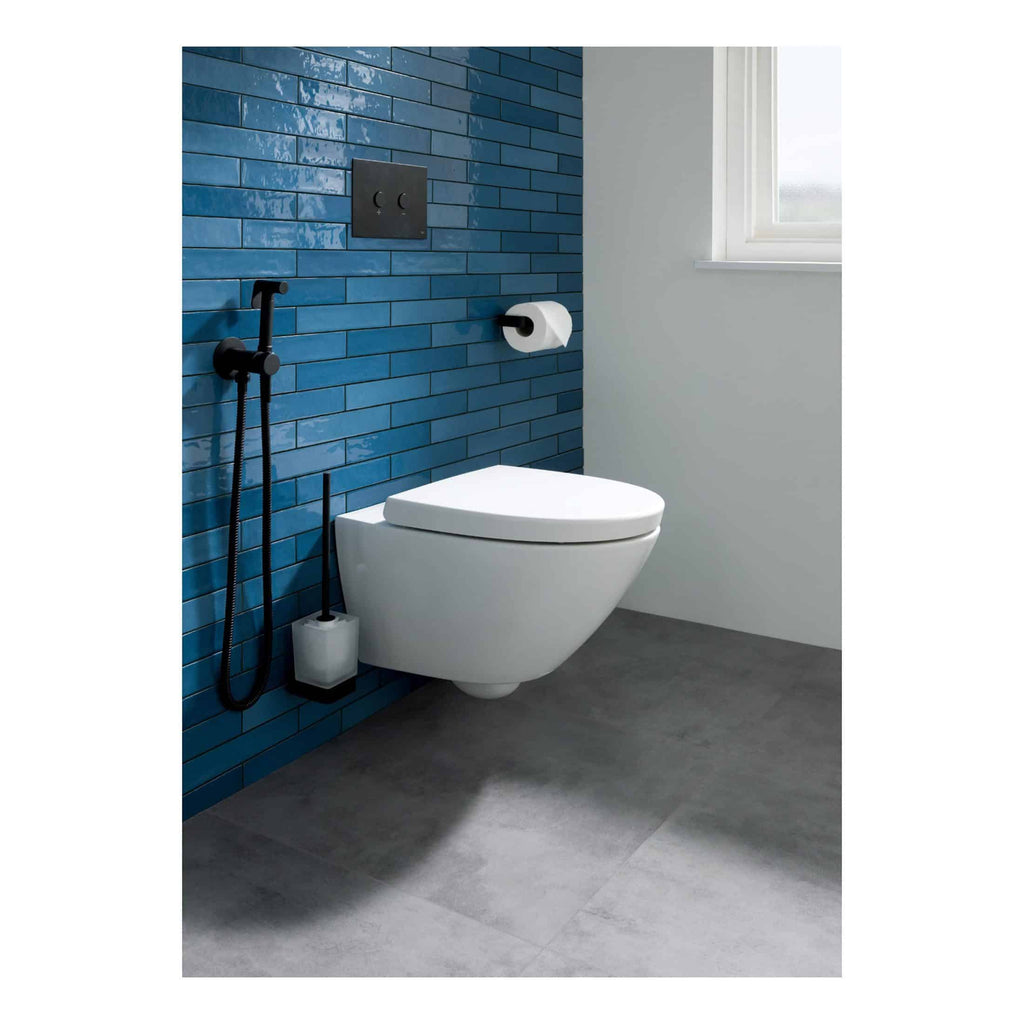 Modern wall-mounted toilet with black bidet spray and white toilet paper holder against a blue tiled wall in a contemporary bathroom.