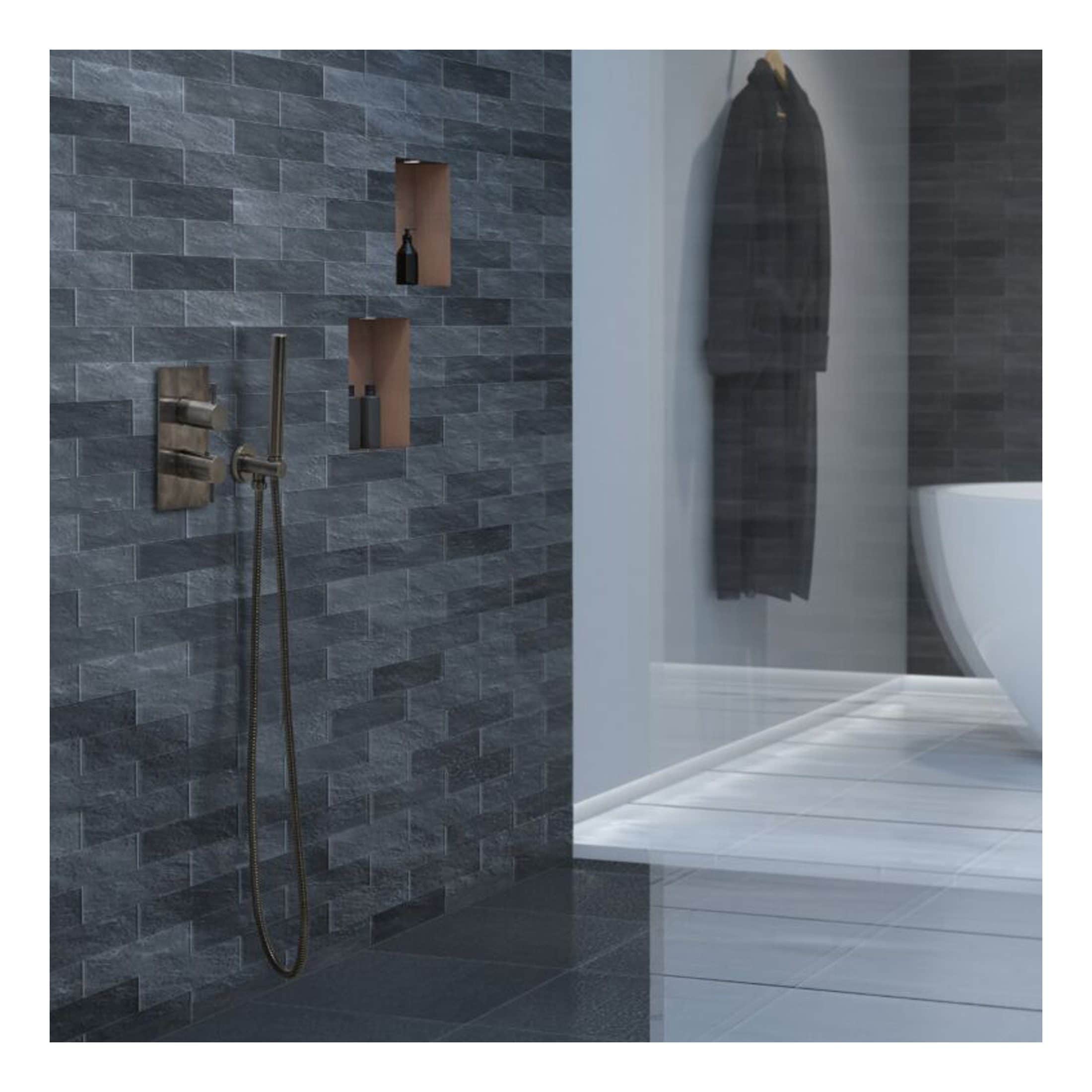 Sleek modern bathroom with grey textured tiles, wall-mounted shower fixtures, built-in shelves, and a contemporary white toilet, showcasing elegant Bubly Bathrooms design.