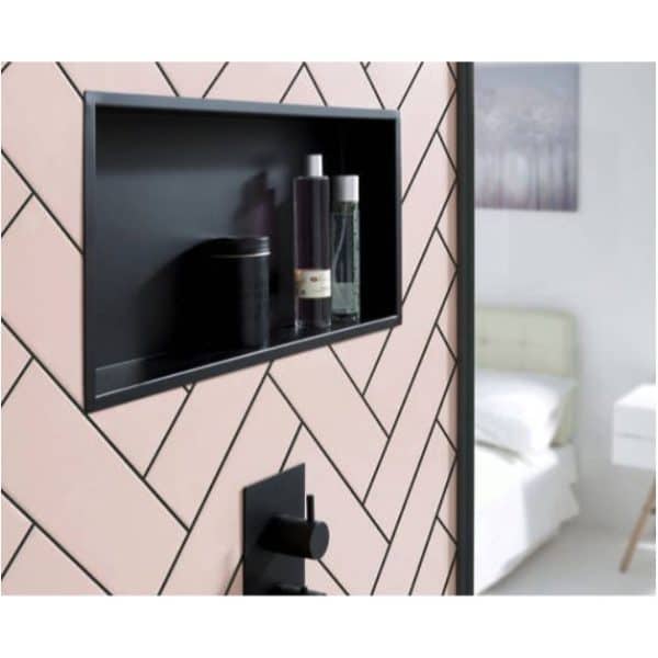 Modern bathroom shower niche with black shelf and shower controls, stylish geometric pink and black tiled wall, functional bathroom storage, and contemporary design.