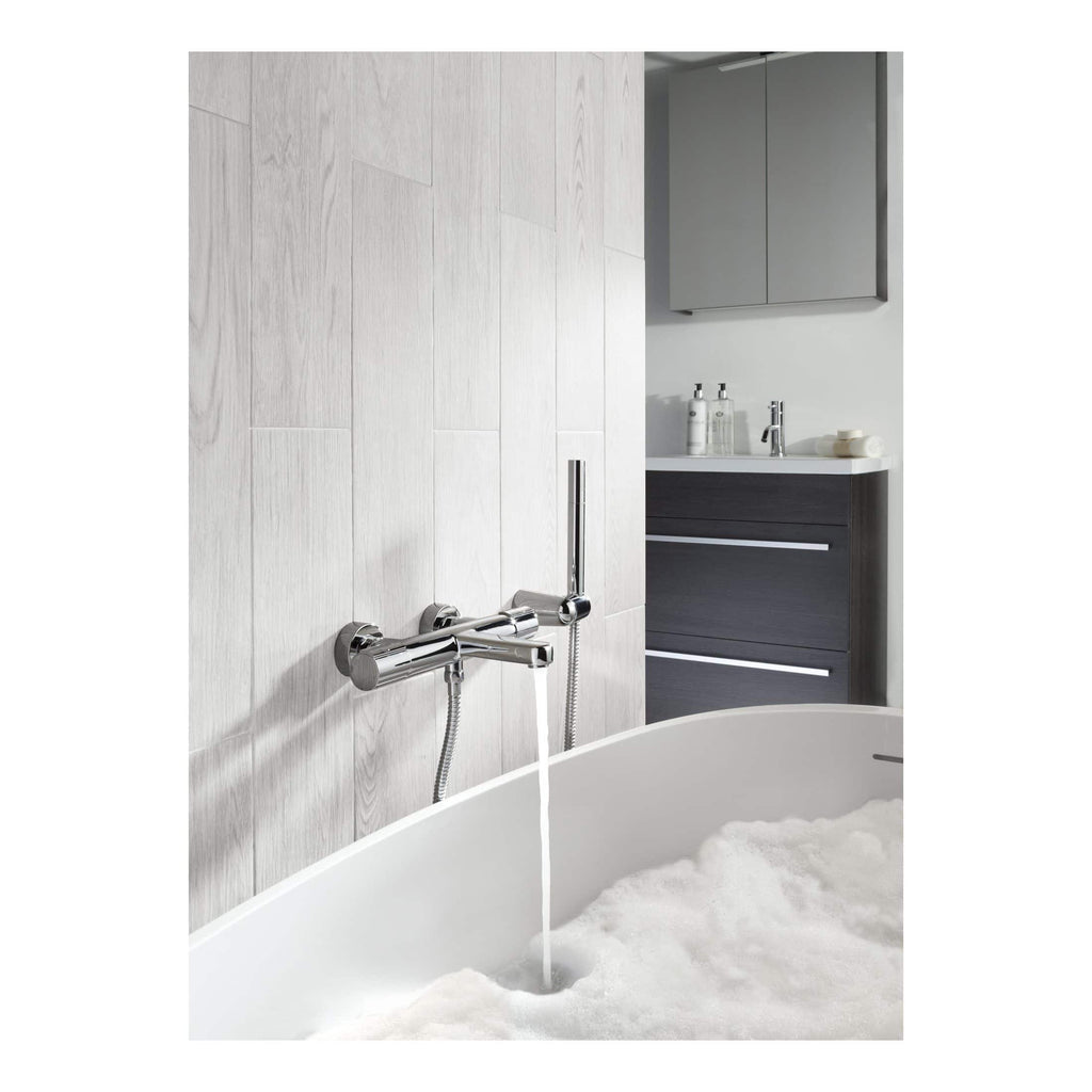 Contemporary bathroom with wall-mounted chrome bath mixer tap and handheld shower, minimalistic grey vanity unit with integrated handles, modern mirror cabinet, white bathroom accessories, and a clean, sleek design ideal for modern bathrooms.