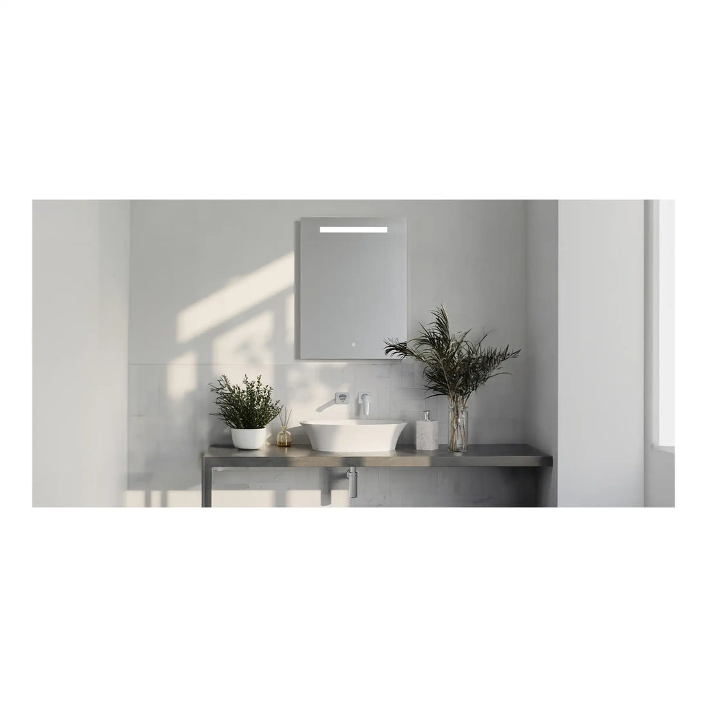Contemporary minimalist bathroom featuring a sleek vessel sink, large mirror with integrated lighting, and elegant decor with green plants, creating a clean and serene atmosphere.
