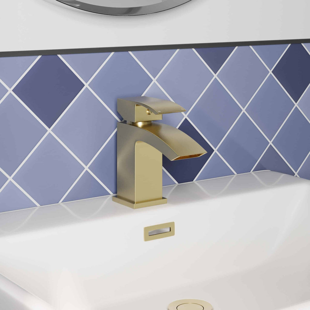 Sleek modern bathroom tap in brushed gold finish on blue tiling background. Perfect for contemporary Bubly bathrooms with stylish fixtures and high-quality bathroom accessories.