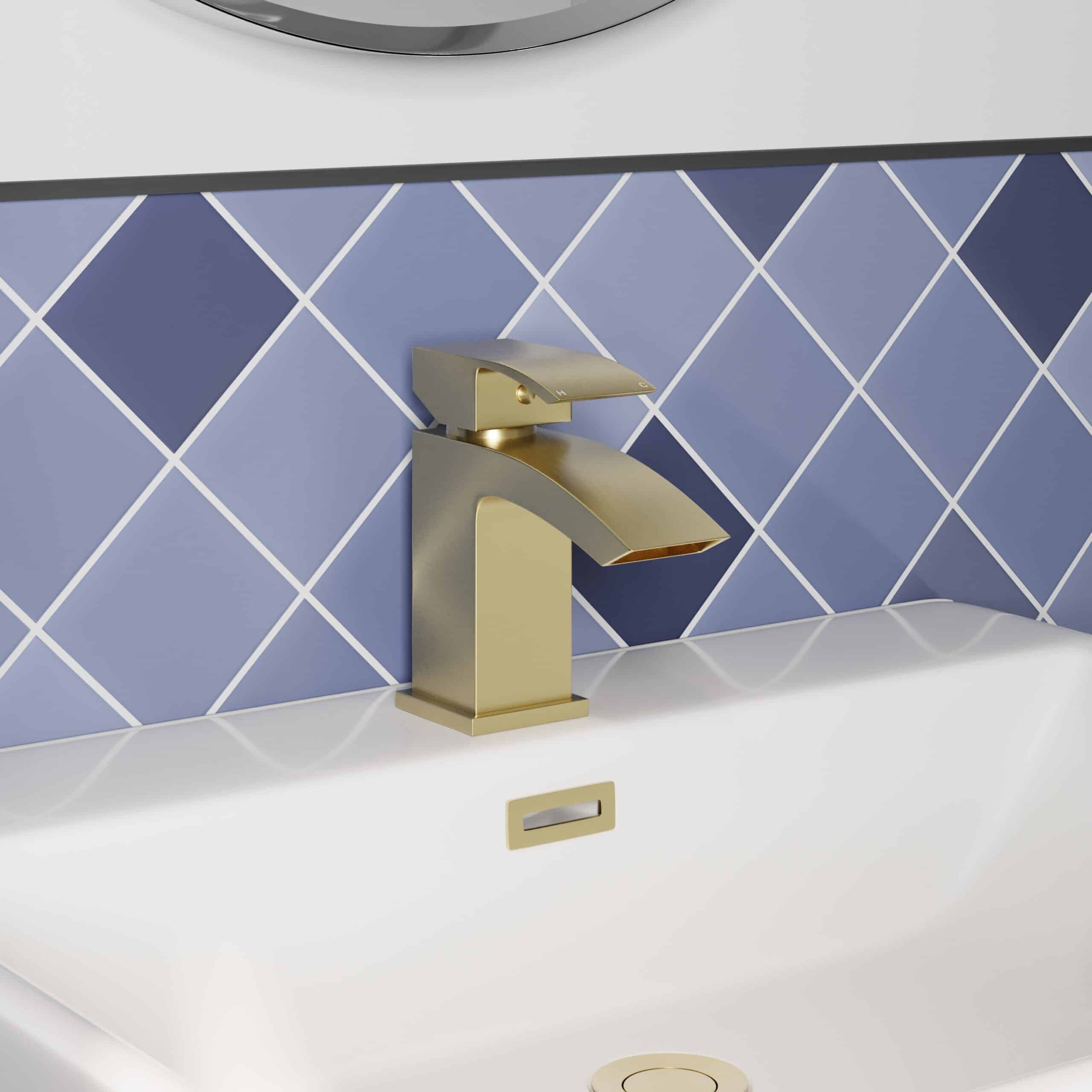 Sleek modern bathroom tap in brushed gold finish on blue tiling background. Perfect for contemporary Bubly bathrooms with stylish fixtures and high-quality bathroom accessories.
