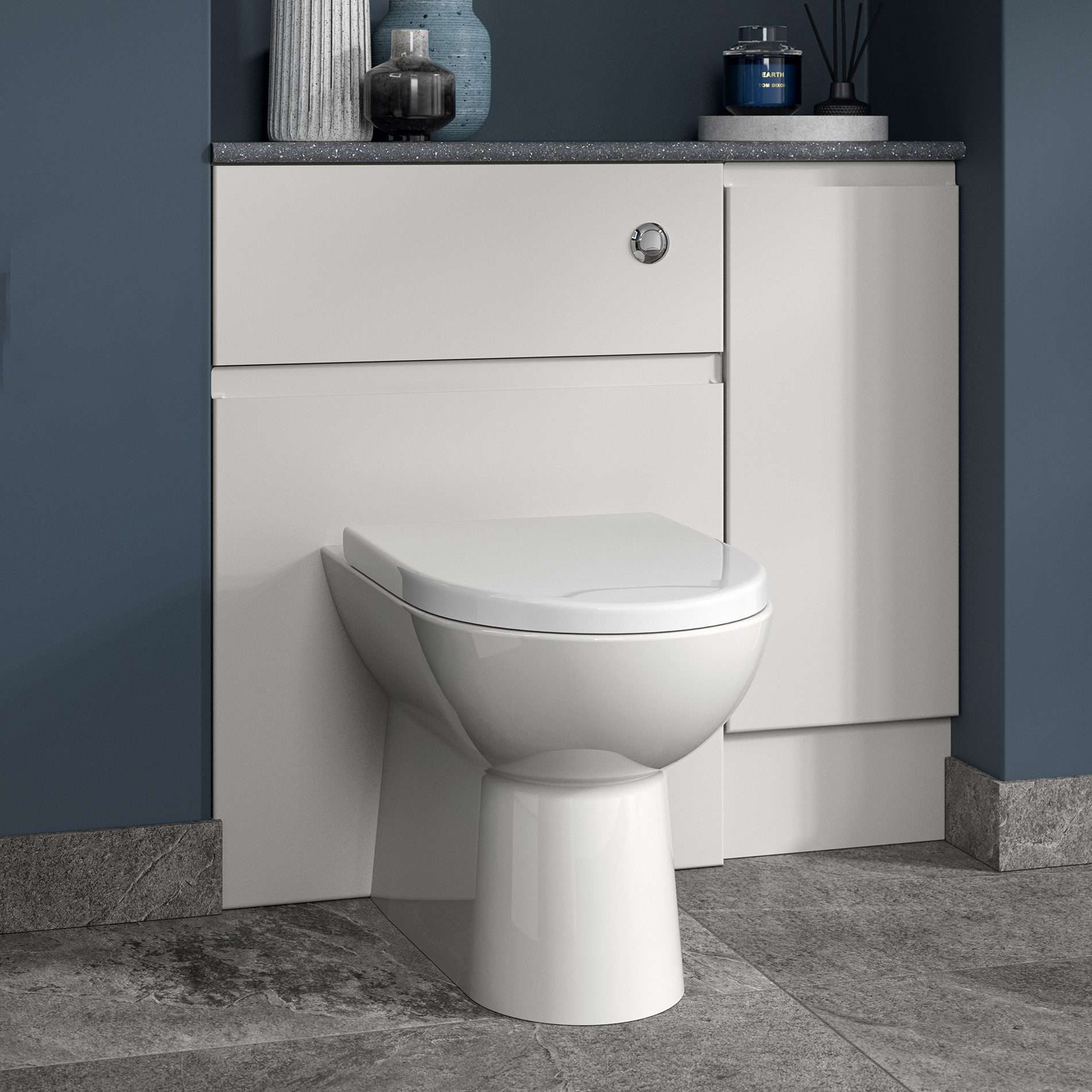 Contemporary white toilet and cabinet with modern bathroom accessories on a grey countertop, blue wall, highlighting stylish and functional bathroom design.