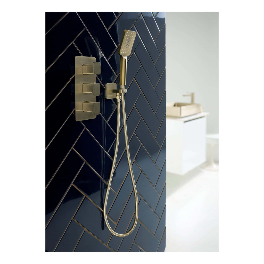 Brass modern shower panel with handheld showerhead and controls, installed on a dark tiled bathroom wall, creating a stylish and contemporary bathroom design perfect for luxury bathroom upgrades.