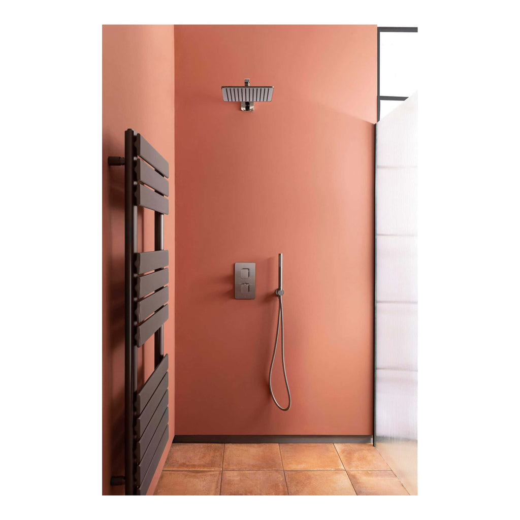 Contemporary walk-in shower with rainfall showerhead, wall-mounted controls, and sleek fixtures, featuring a warm peach-toned wall and modern radiator, designed for stylish and functional bathroom interiors.