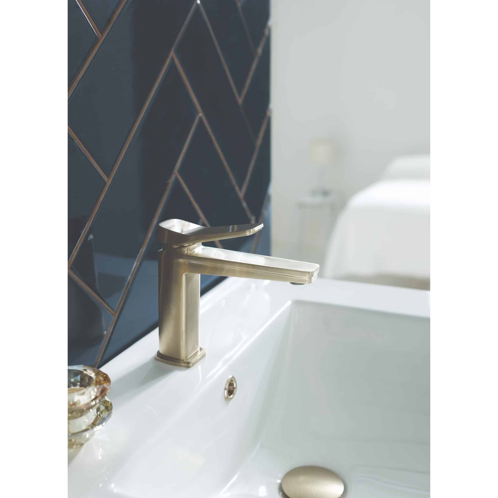 Sleek modern bathroom sink with brass faucet, set against stylish dark tile wall, showcasing luxury bathroom design and plumbing fixtures for enhanced bathroom aesthetics.
