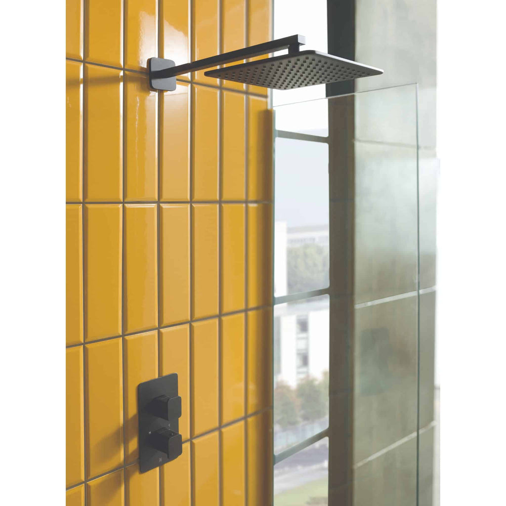 Modern black square rainfall shower head and wall mixer taps in yellow tiled bathroom, contemporary bathroom shower design, high-quality bathroom fixtures, stylish modern bathroom decor.