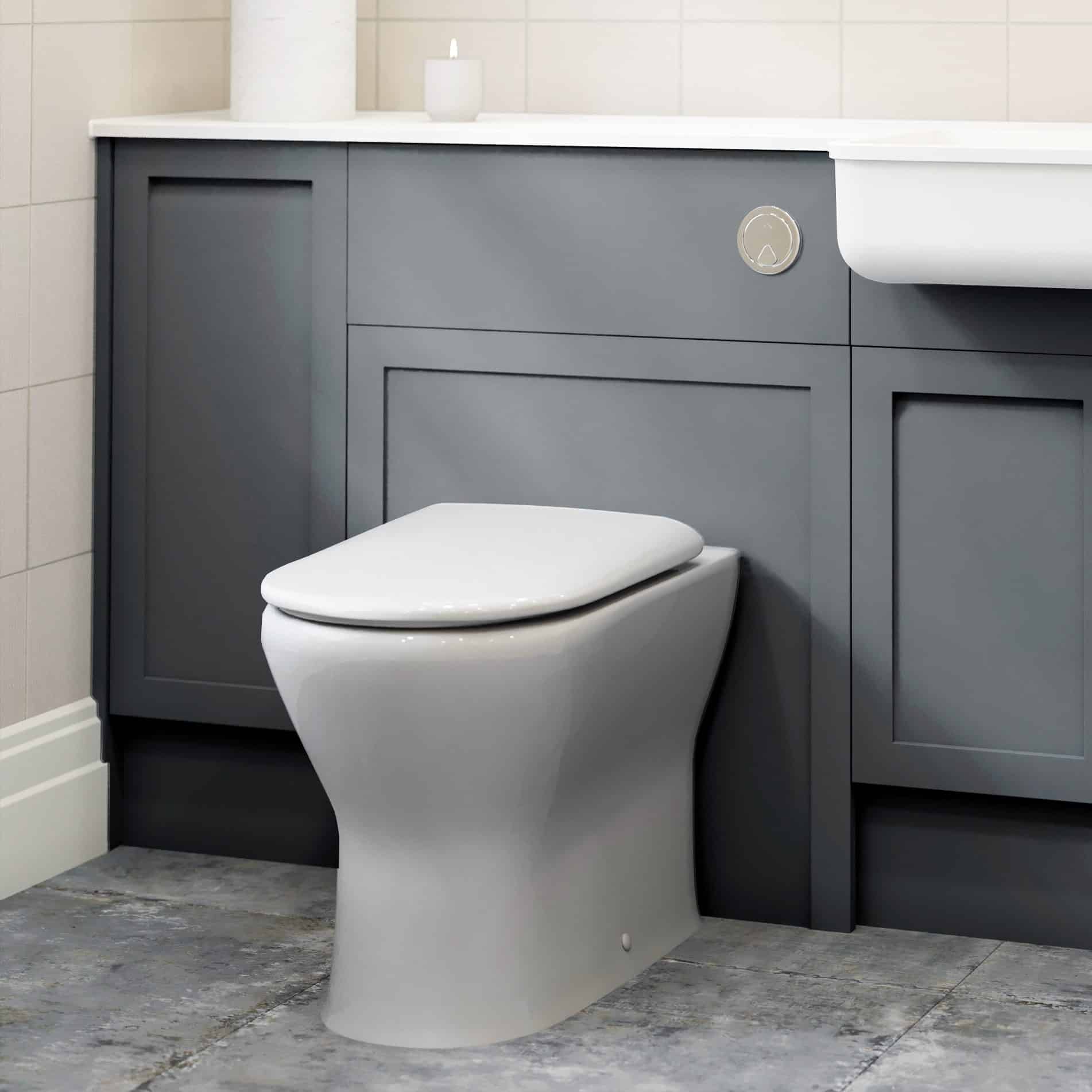 Contemporary white toilet with sleek design positioned against a dark grey bathroom vanity with white countertop in a modern bathroom setting.