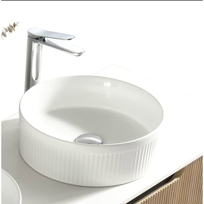 Polished white ceramic bathroom sink with a modern design and chrome single lever mixer tap, ideal for contemporary bathroom vanity units.