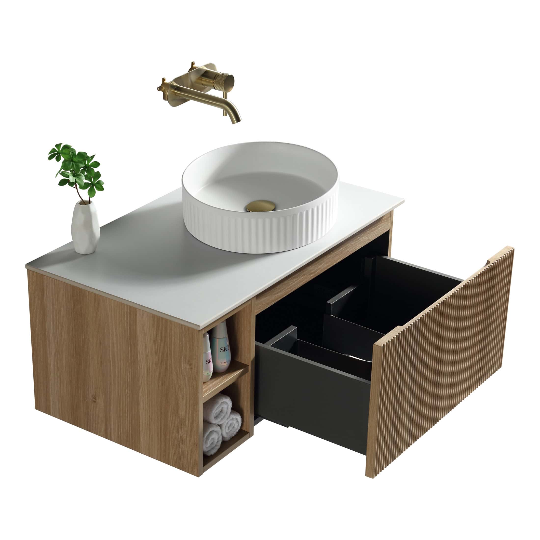 Sleek modern bathroom vanity with a round white vessel sink, brass wall-mounted faucet, wooden cabinet with open shelves and black storage drawers, accessorised with a small green plant.
