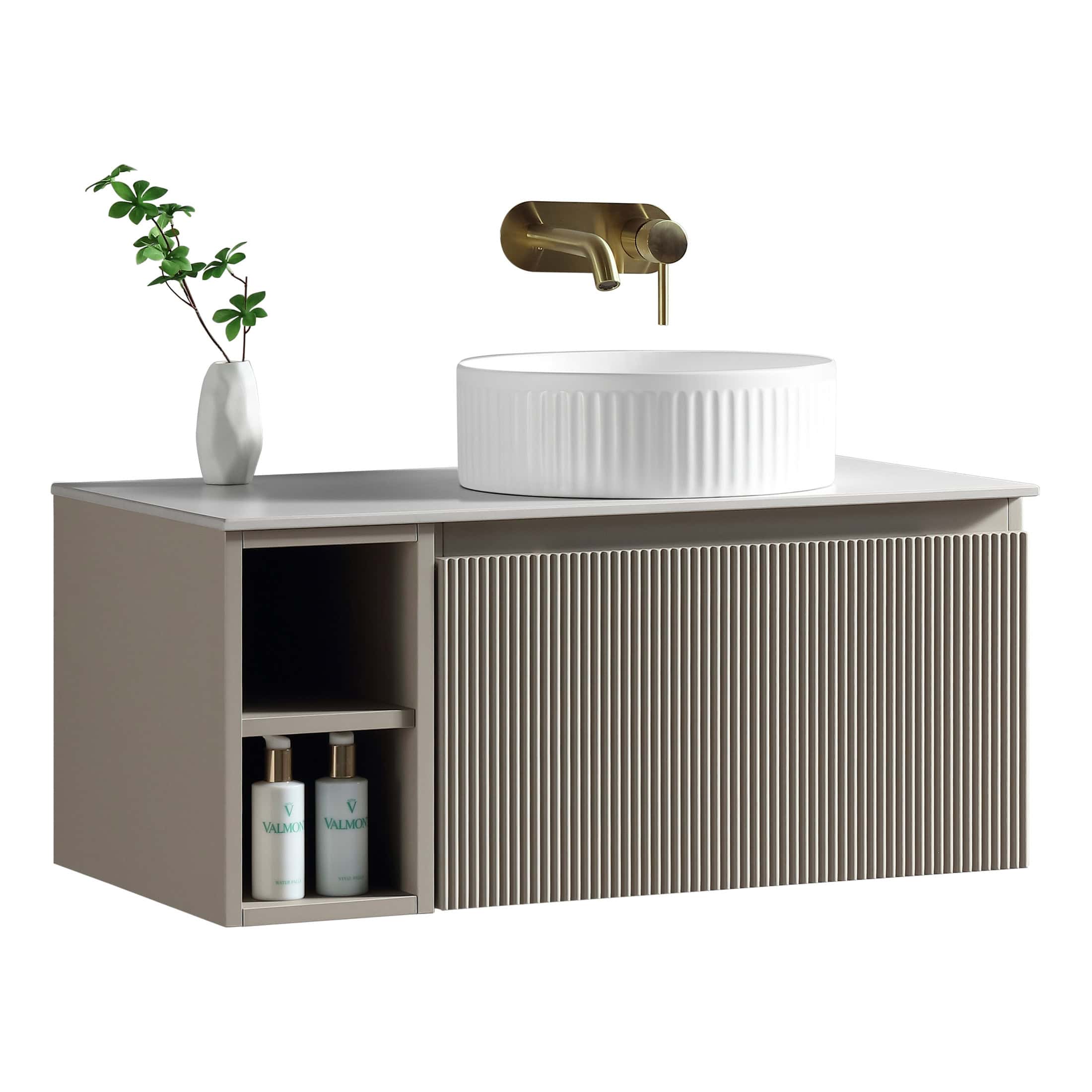 Sleek modern bathroom vanity with ribbed drawer front, white countertop, and stylish basin, complemented by a gold wall-mounted tap and a decorative plant in a white vase. Perfect for contemporary bathroom decor.