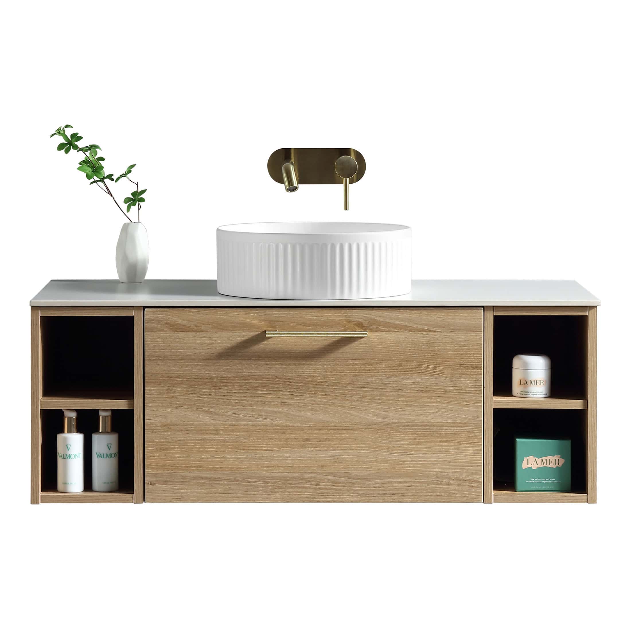 Elegant modern bathroom vanity featuring a white ceramic vessel sink, brass wall-mounted tap, minimalist wooden cabinet with open shelving, and decorative botanical element for contemporary bathroom design.
