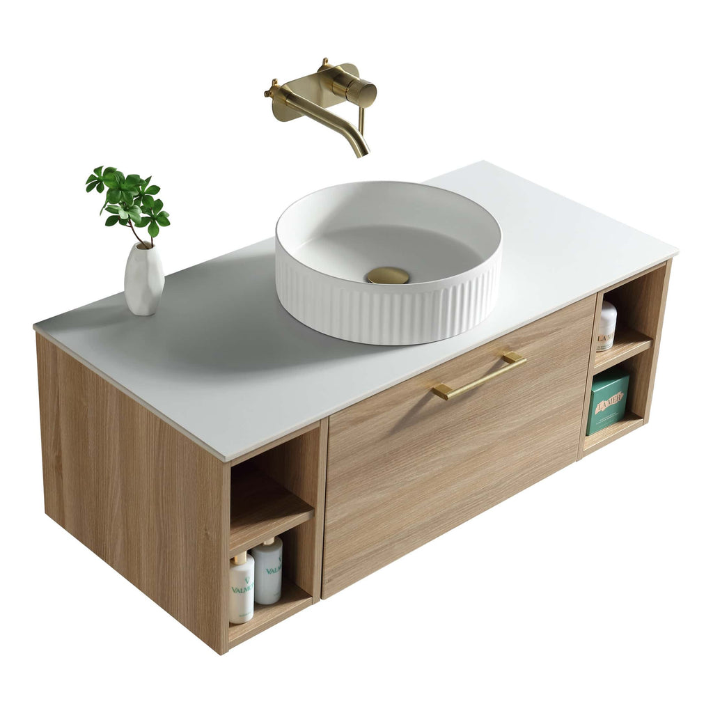 Polished white bathroom vanity with a modern round ceramic sink, brass faucet, and natural wood cabinet featuring open shelving for storage and decor.