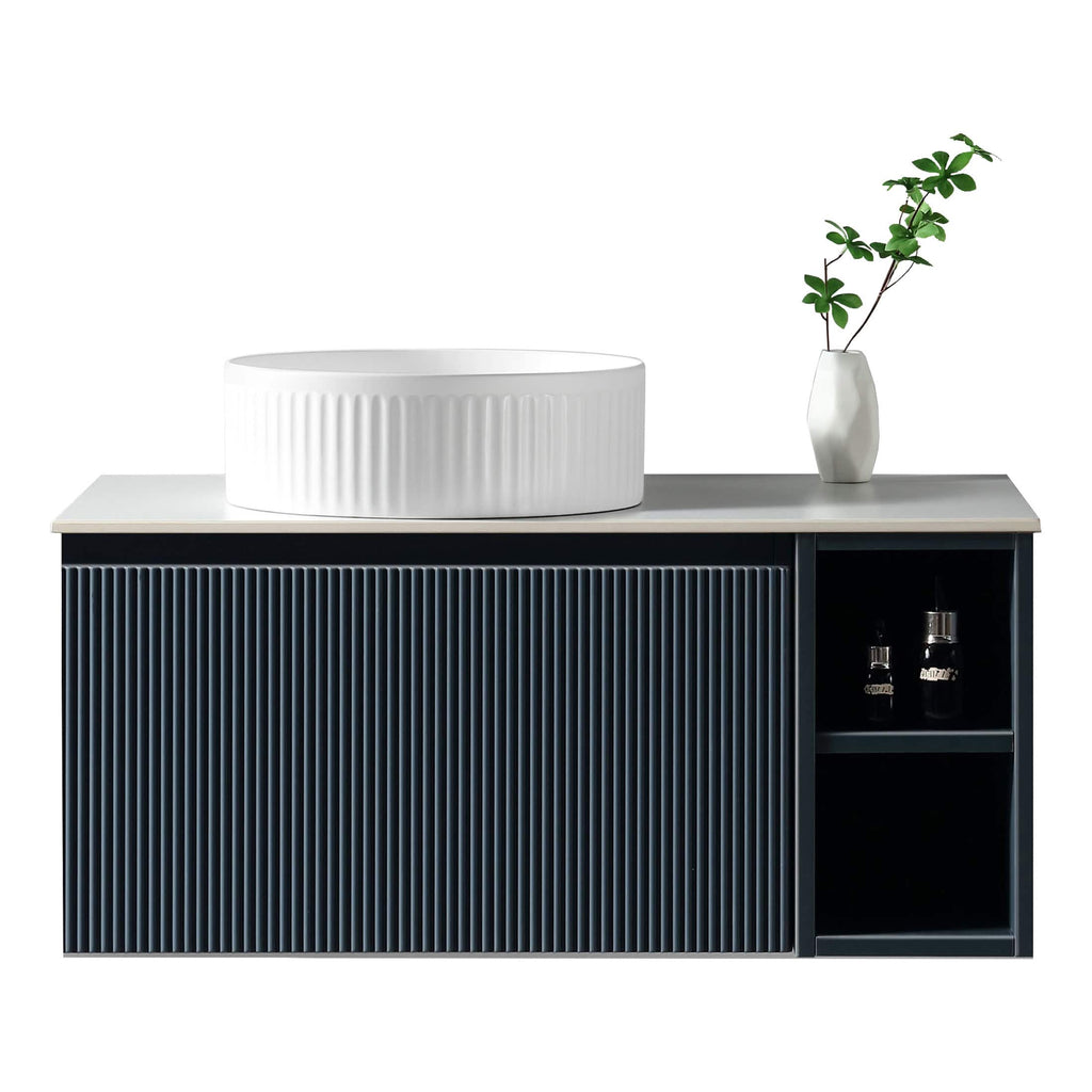 Sleek modern bathroom vanity with a minimalist design, featuring a textured black cabinet and a white vessel sink with vertical ridges, complemented by a white vase with greenery.