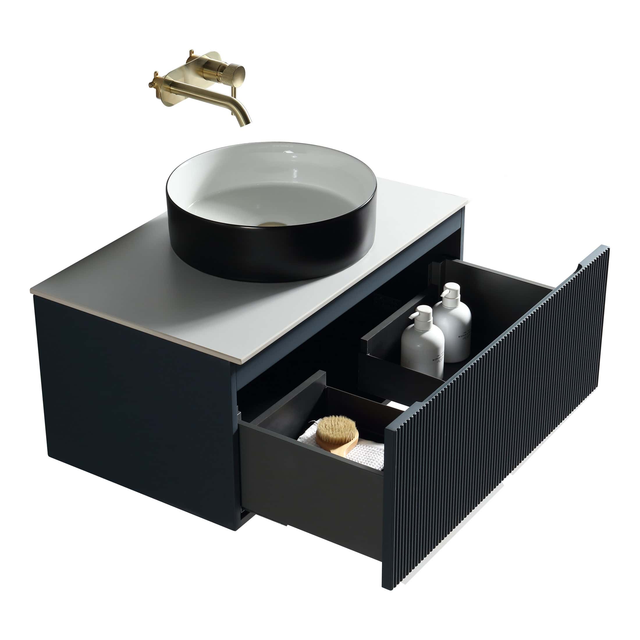 Contemporary black bathroom vanity with a stylish round vessel sink and brass wall-mounted tap, featuring open storage drawers with toiletries and accessories for modern bathroom design.