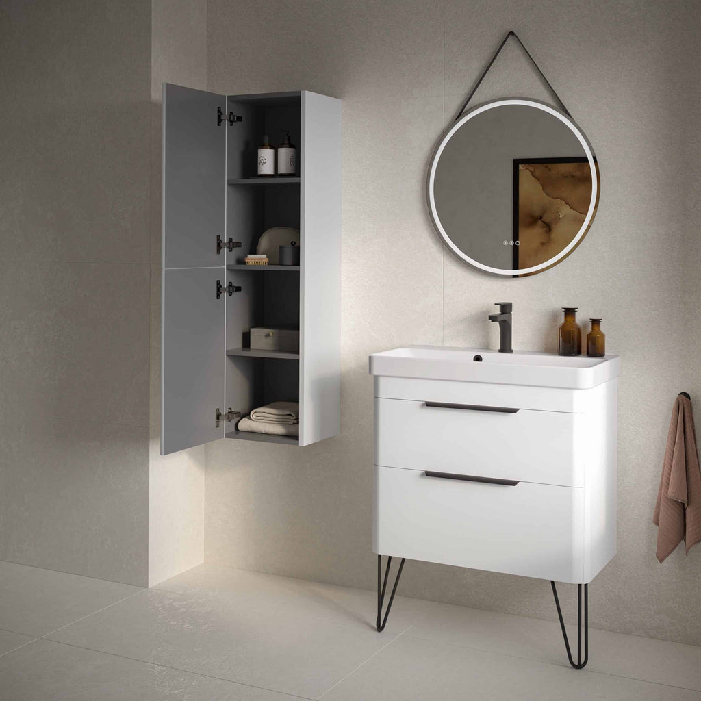 Modern white bathroom vanity with integrated sink, stylish black hardware, and sleek design; complemented by a wall-mounted grey storage cabinet and round mirror with LED lighting in contemporary bathroom setting.