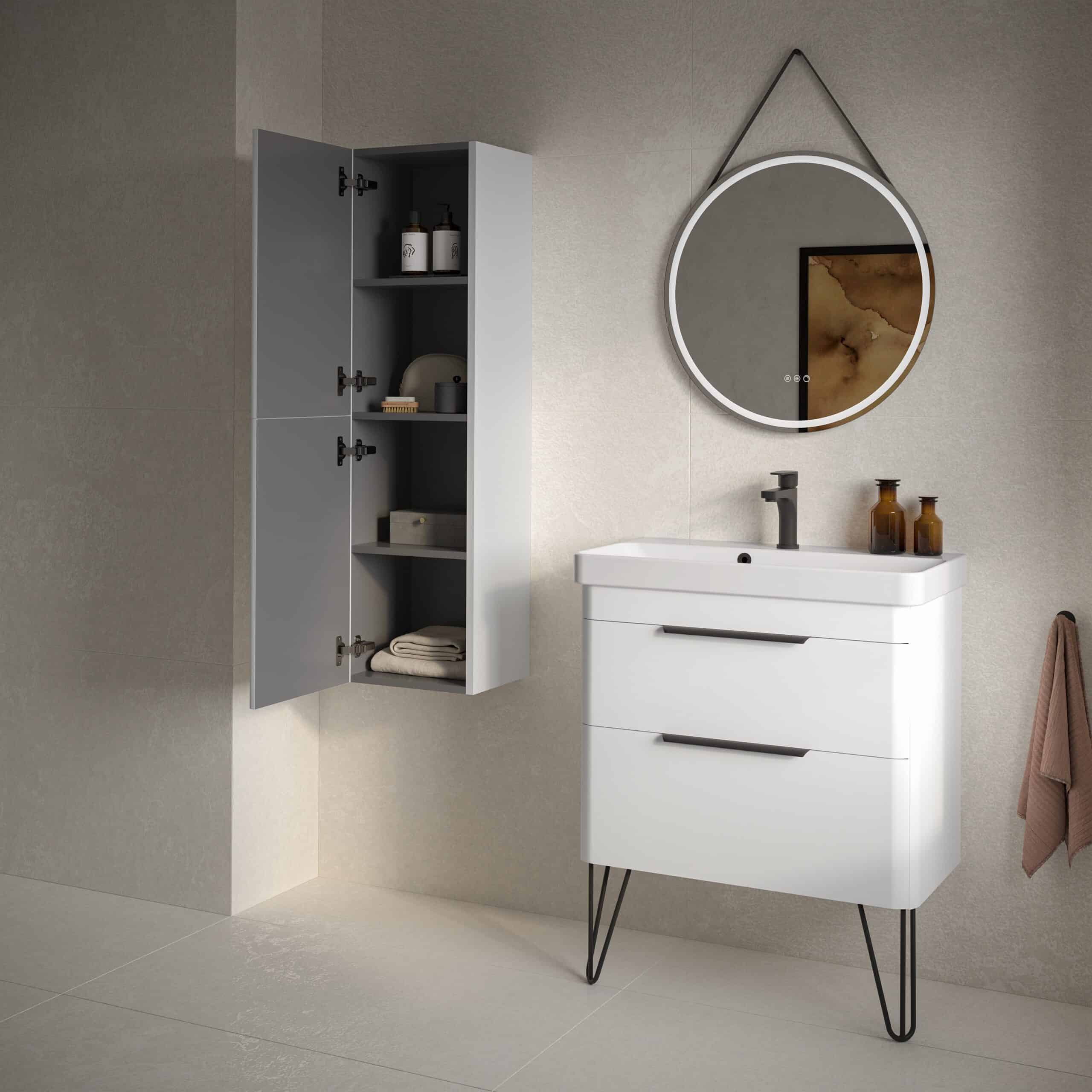 Modern white bathroom vanity with integrated sink, stylish black hardware, and sleek design; complemented by a wall-mounted grey storage cabinet and round mirror with LED lighting in contemporary bathroom setting.