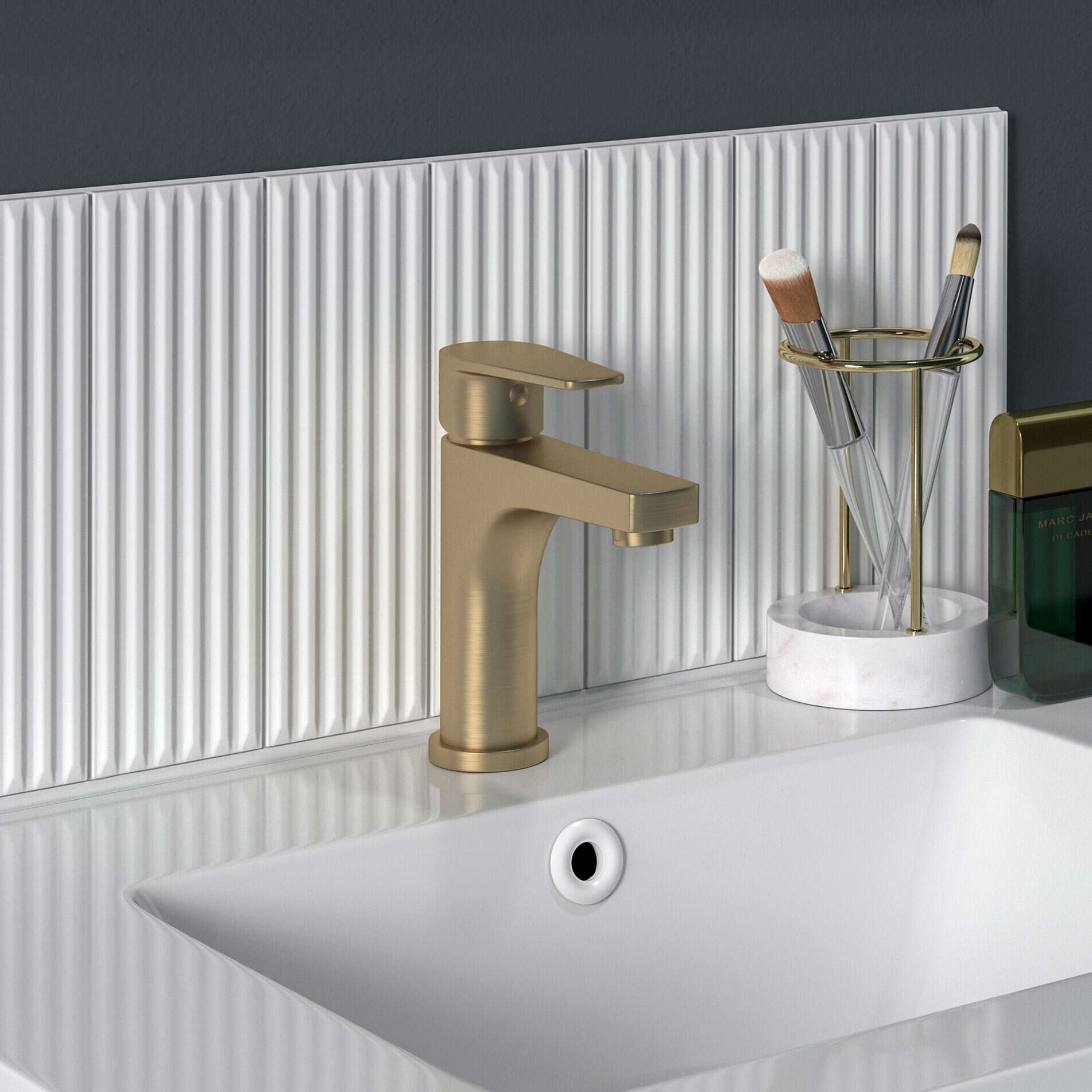 Sleek brushed gold bathroom faucet installed on a white ceramic sink with modern accessories, ideal for contemporary bathroom designs, offering style and functionality.