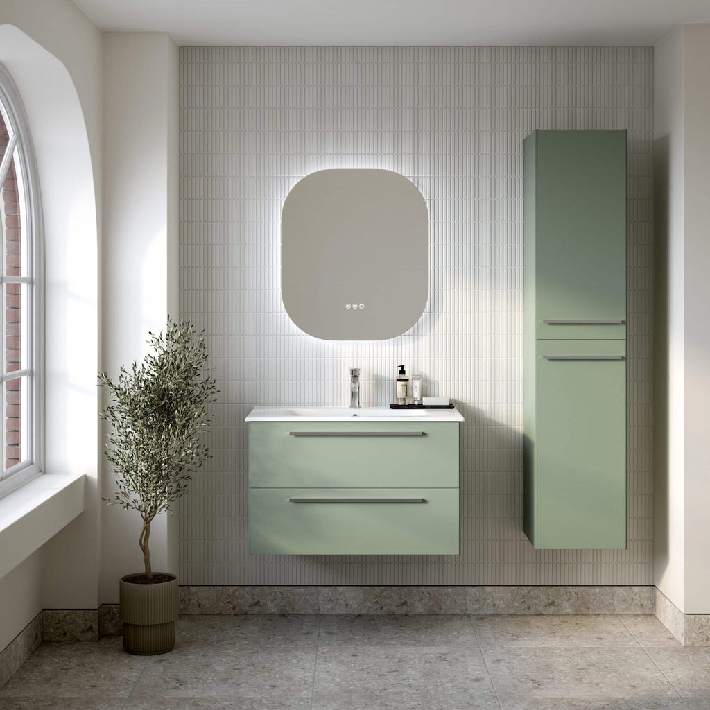 Minimalist bathroom with green vanity units and a large backlit mirror, featuring modern fittings and natural light from a nearby window.