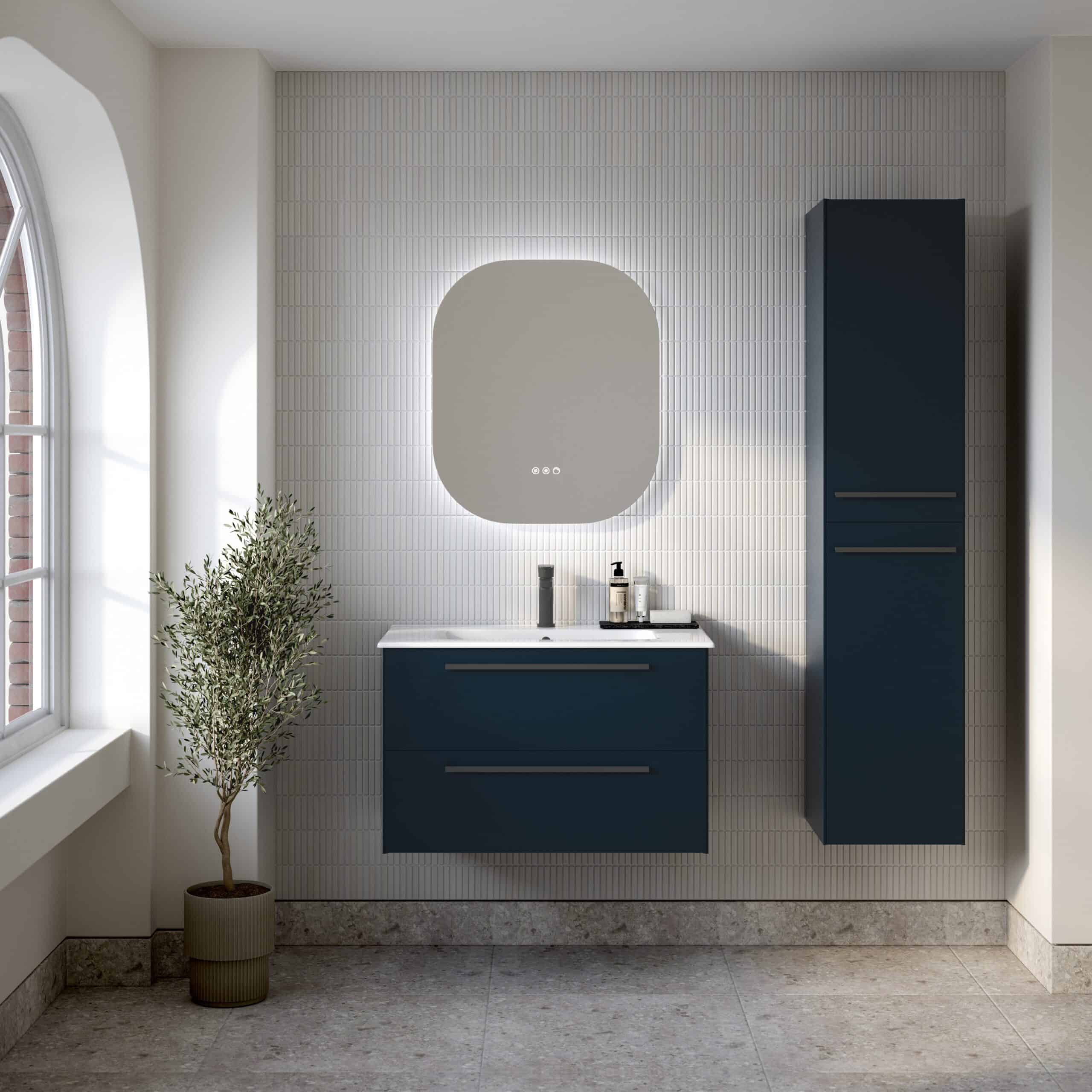 Modern bathroom vanity with navy blue cabinets and a white countertop, illuminated mirror, and matching tall storage cabinet, contemporary design with minimalistic accessories, natural light from the window, and a potted plant.