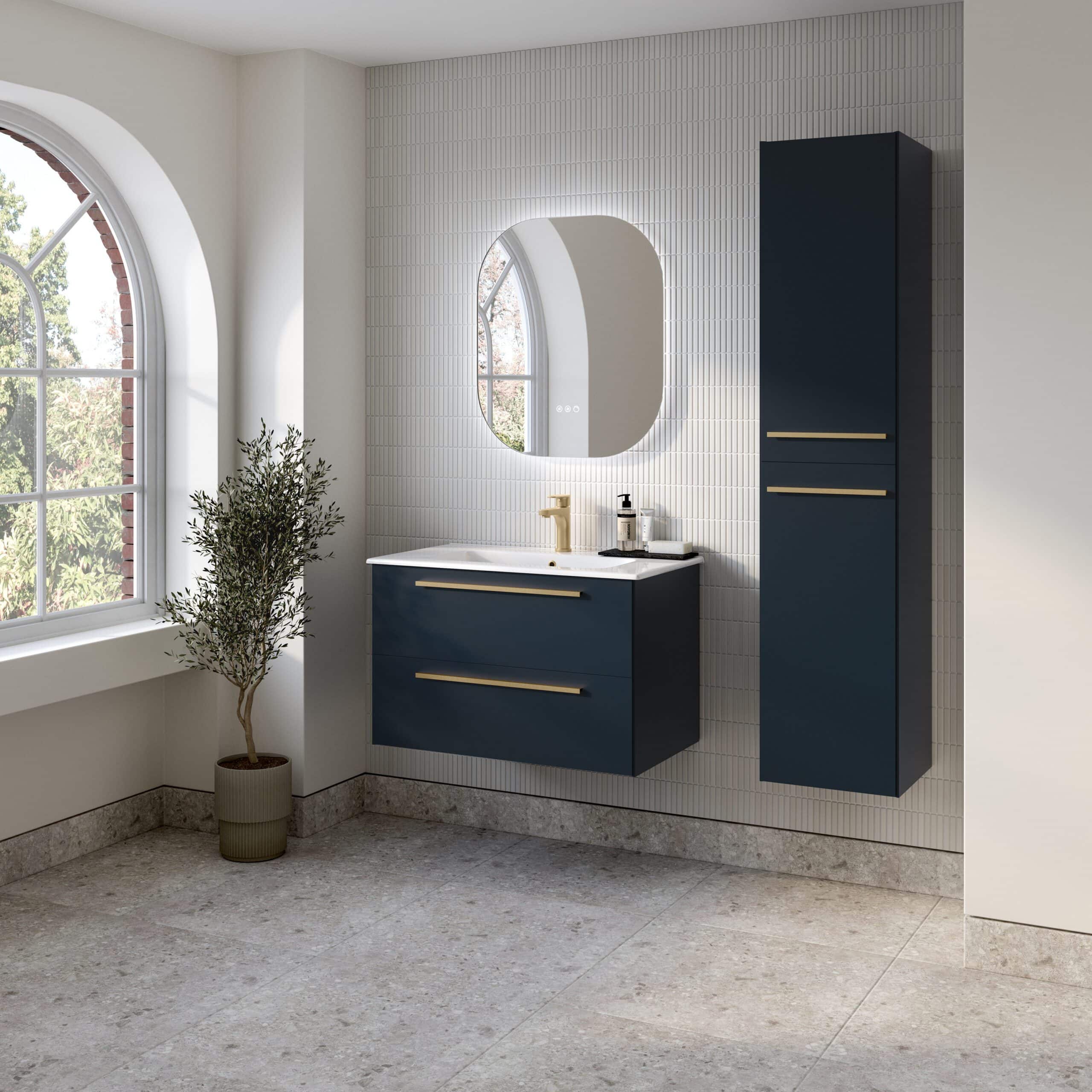 Contemporary navy blue bathroom vanity with gold accents, wall-mounted mirror, and matching tall storage cabinet in a bright, modern bathroom with large arched windows and natural light.