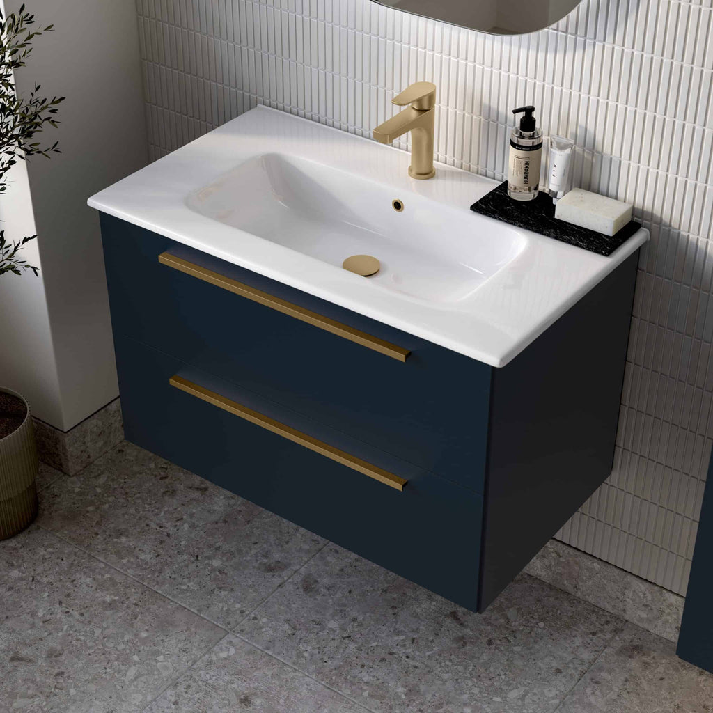 Sleek navy blue bathroom vanity with white ceramic sink, gold fixtures, and modern accessories, perfect for contemporary bathroom designs.