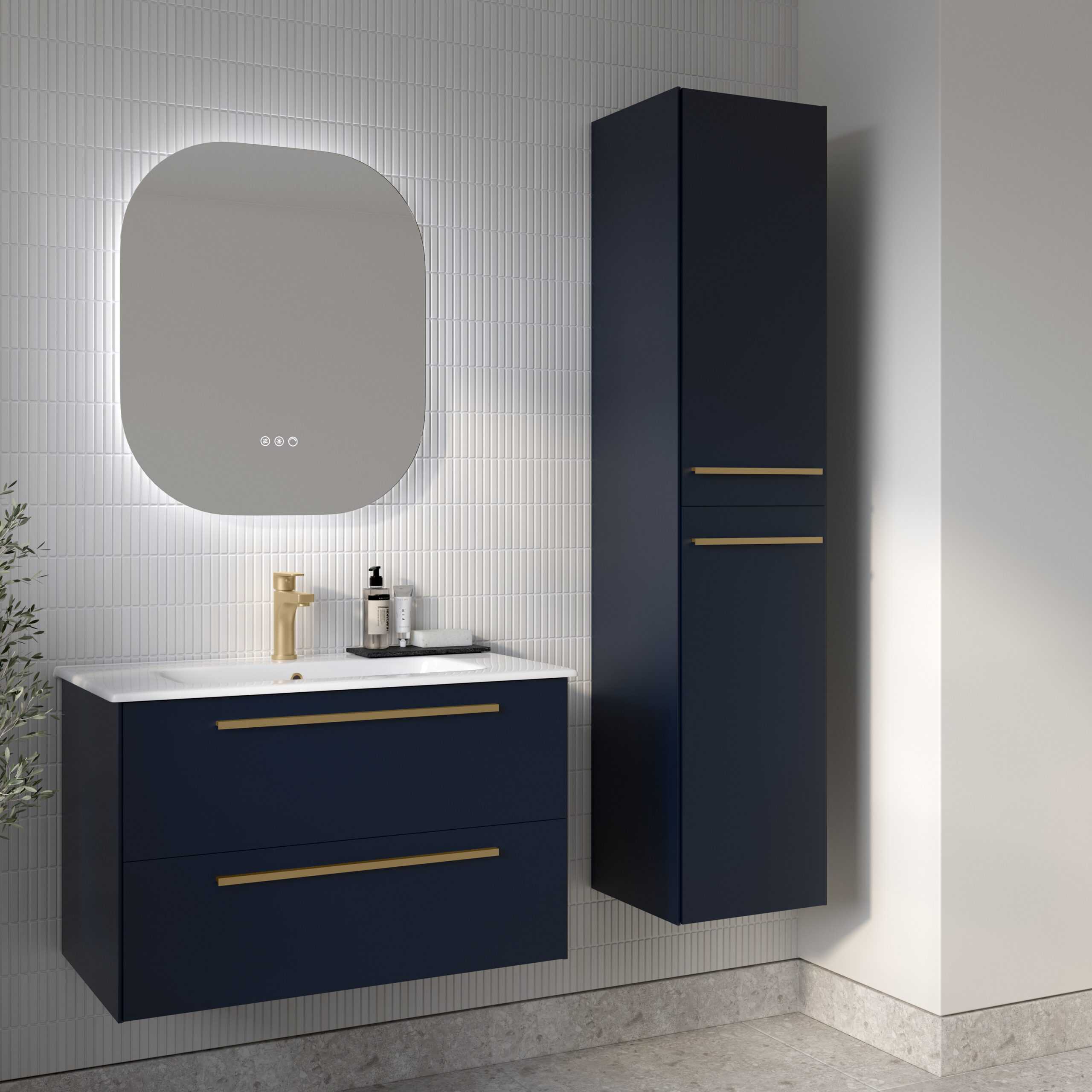 Sleek navy blue bathroom vanity unit with gold handles and white countertop, paired with a tall matching cabinet, set against modern white tiled walls with backlit mirror for stylish bathroom design.