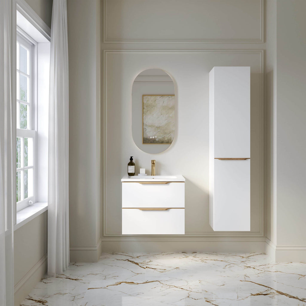Modern white bathroom vanity with a sleek mirror and elegant storage cabinets, featuring gold accents, in a bright, minimalist space with marble flooring and natural light from a large window.